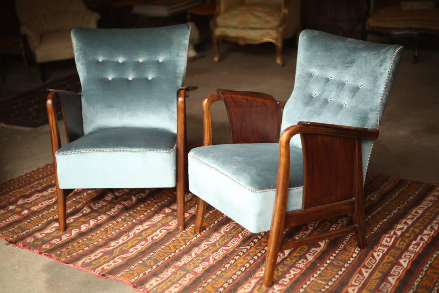 These are a very stylish pair of midcentury Danish designed armchairs. The shape of these chairs makes them extremely attractive and very elegant. The upholstery is not original nor new but it is in extremely good condition with only light wear to