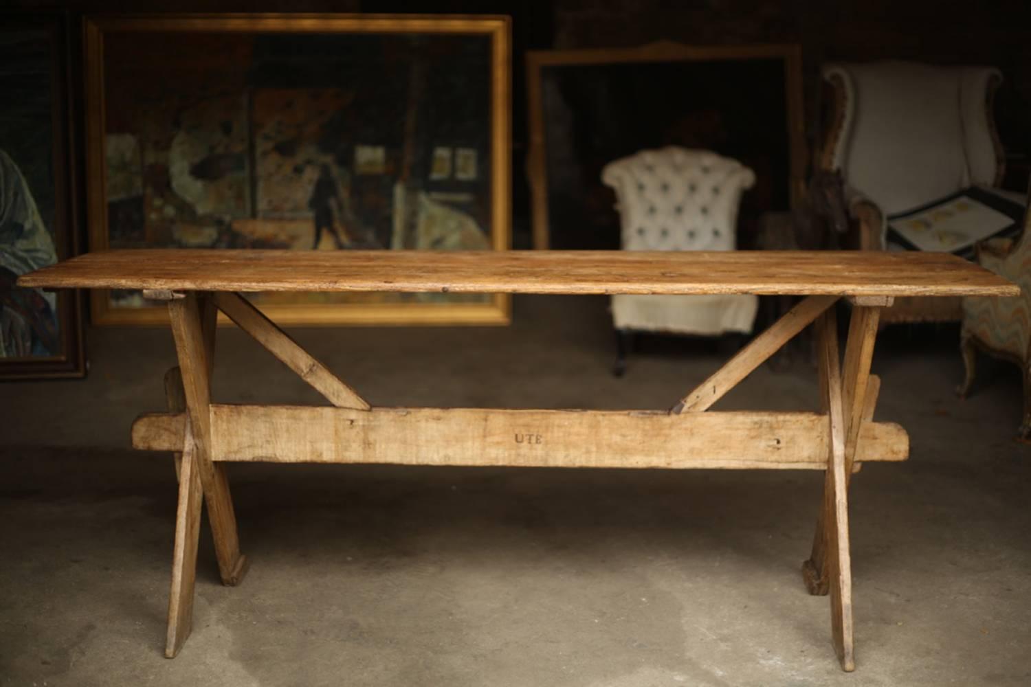 This is an exceptional 18th century X-frame tavern table. It is a superb design with a very simplistic construction but very high quality. It has honest old repairs to the feet (additions) and stretchers (iron bracket support). The top has some
