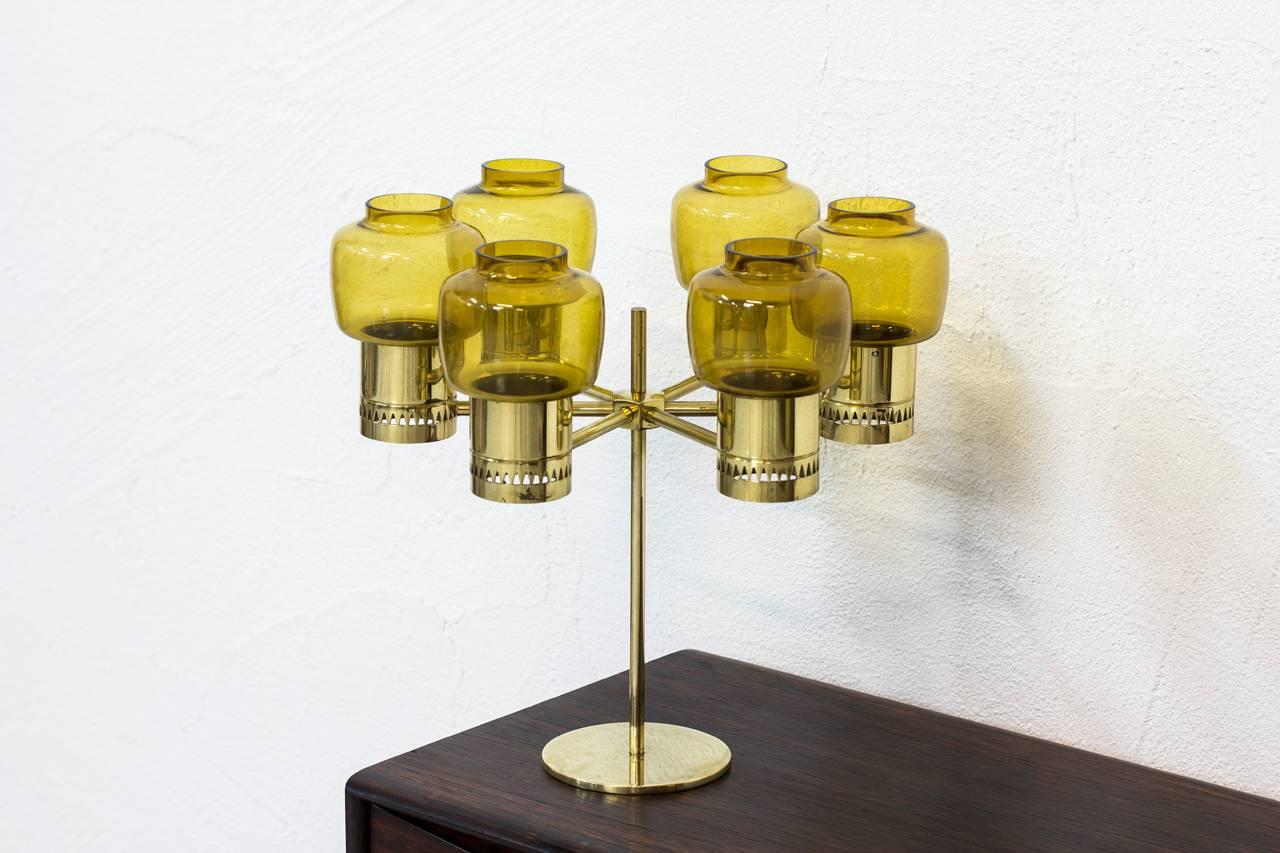 Very rare six–armed candelabrum designed by Hans-Agne Jakobsson. Produced by his own company at Markaryd, Sweden during the 1960s.
Polished brass with handblown amber colored glass shades. Excellent condition with minor wear and age related patina.