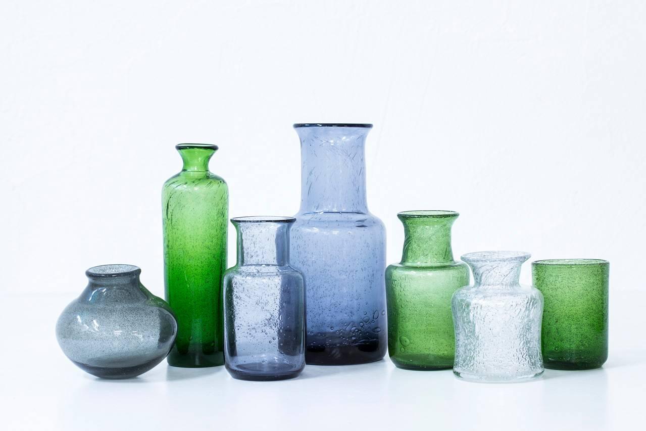 Group of seven glass vases designed by Erik Hoglund, handblown at Kosta glass-fabric in Sweden during the1950s. Collection of grey and green vases of various sizes and shapes, all with bubbles in the glass. Six of the vases are engraved with