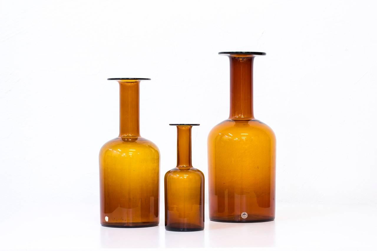 Set of three amber color glass vases designed by Otto Breuer for Kastrup Holmegaard in Denmark during the 1950s. Excellent vintage condition with minor signs of usage (some dirt inside the mid-size one).