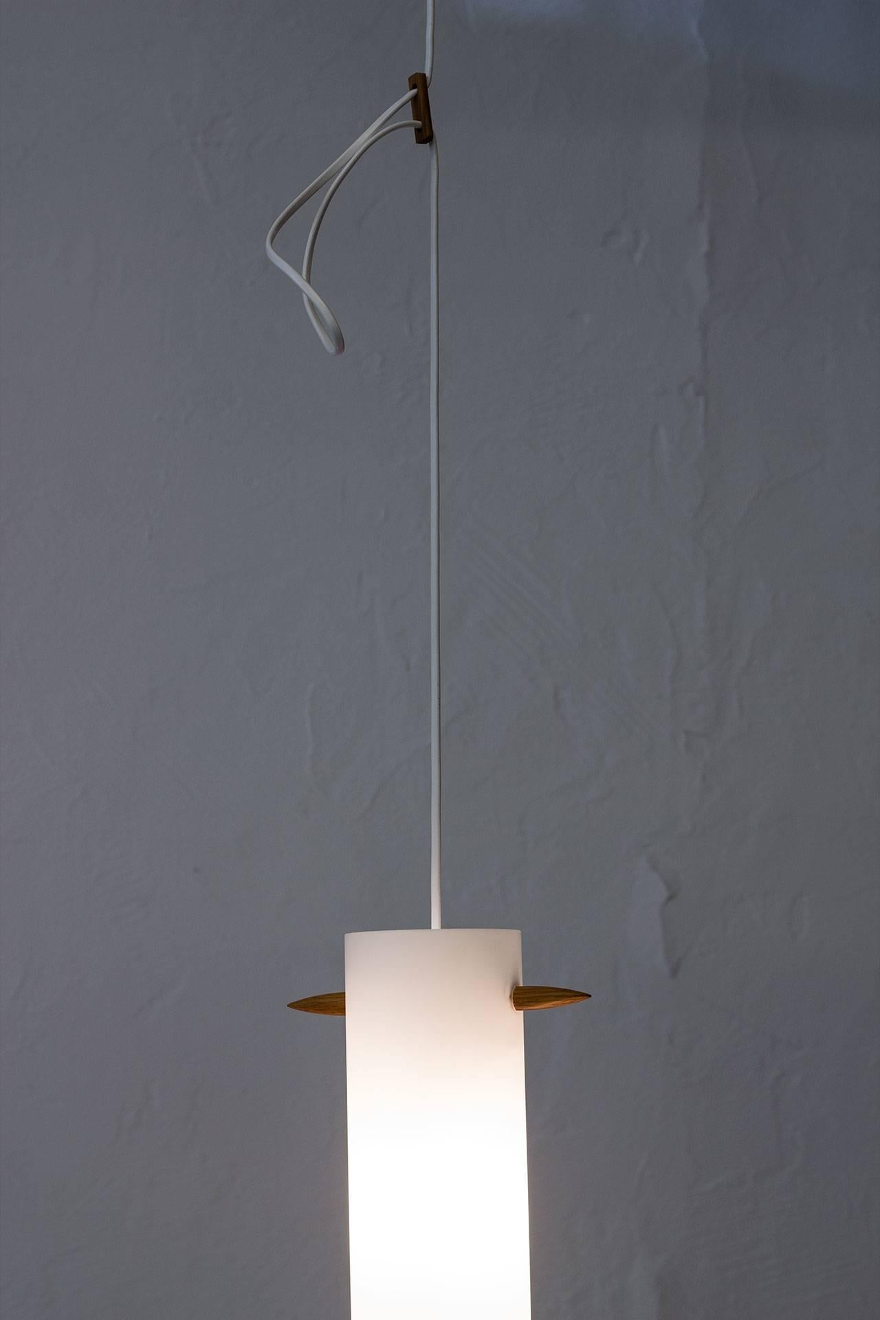 Rare ”535 pendant lamp designed by Uno & Östen Kristiansson for their own company Luxus at Vittsjö, Sweden during the 1950s. Opaline glass and solid oak fitting. New electricity. Excellent condition with minor wear related to age.