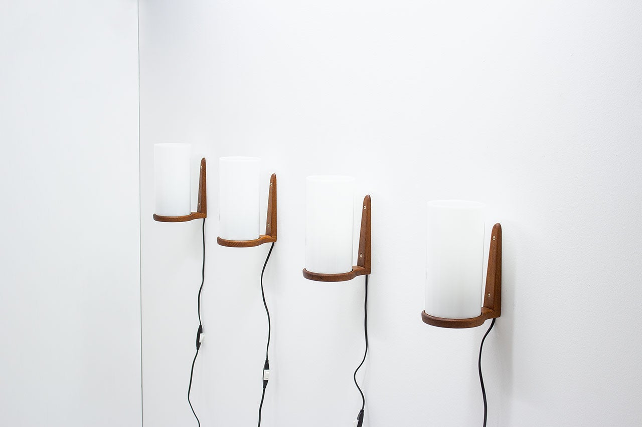 Set di appliques disegnate dai fratelli svedesi Uno & Östen Kristiansson per la loro azienda Luxus. Prodotto a Vittsjö in Svezia alla fine degli anni '50/'60. Le applique sono realizzate con raccordi in teak e diffusori in acrilico. L'elettricità è