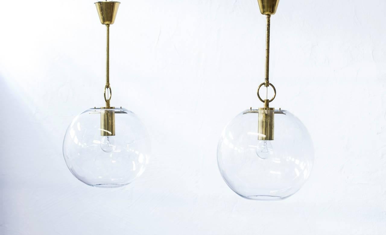 Pair of large pendant lamps designed by Hans-Agne Jakobsson for his own company
at Markaryd, Sweden during the 1960s. Brass stem and fixture with large handblown
clear glass shades.