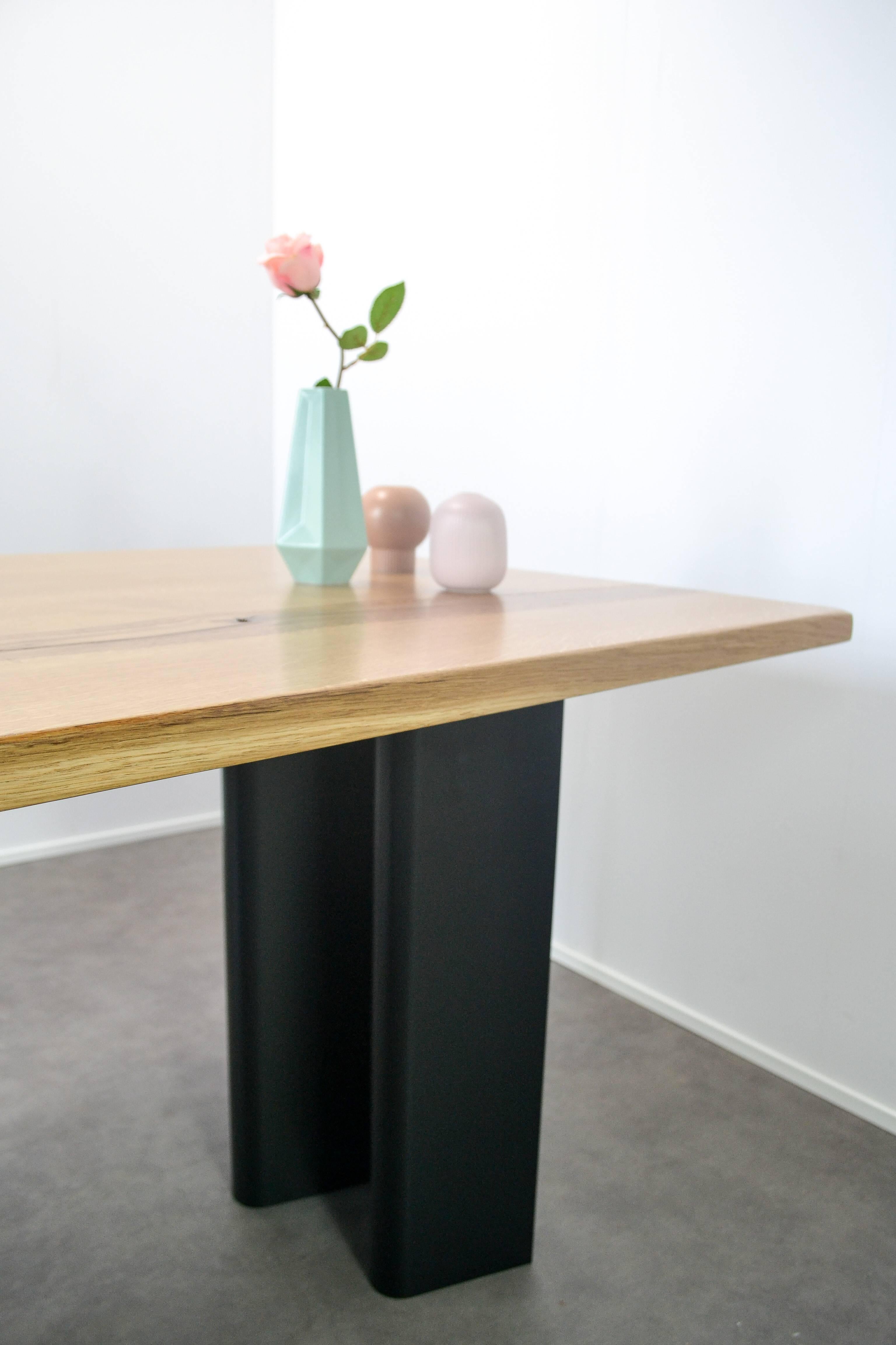 Solid 35mm thick oak dining tabletop, made from a single board of locally sourced oak and sat on a hand folded steel ripple base. 
This board has been cut, reverse matched and finger jointed to create a unique, characterful tabletop with a satin