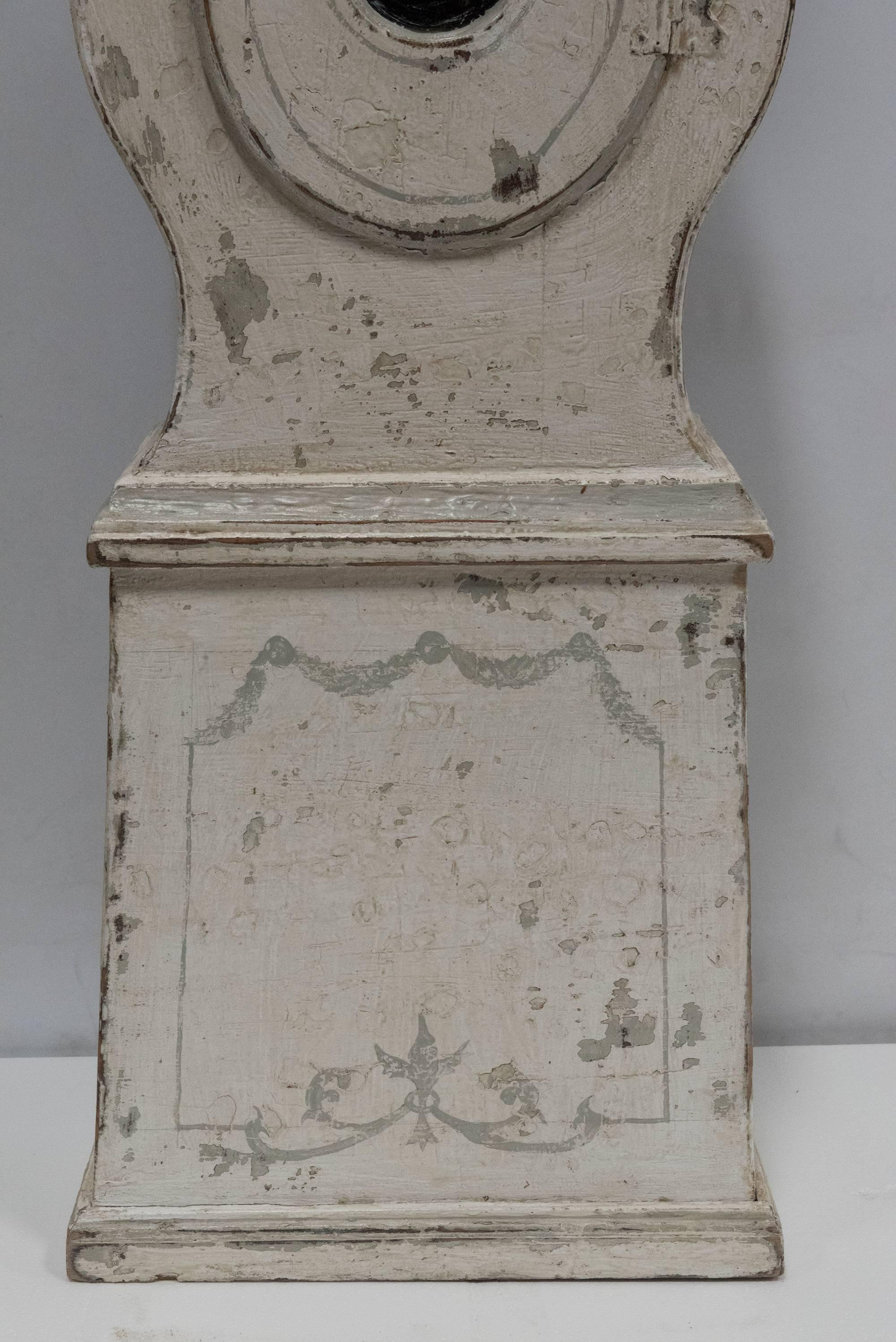 A beautiful white painted Gustavian standing clock with open face and middle that opens. In working condition. Swedish, circa 1780.