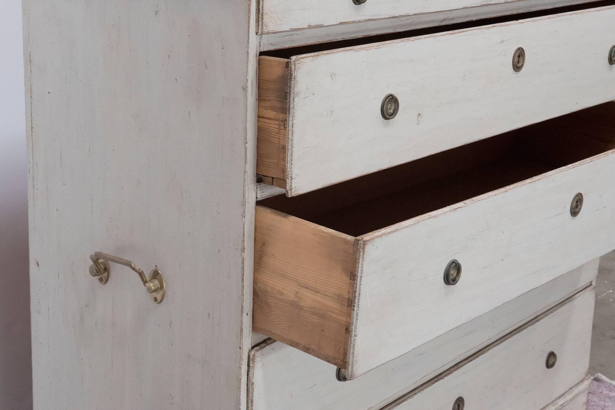 A wonderful Gustavian chest of drawers with five drawers all in working condition. Side has brass hardware handles for easy placement. High chest with scroll-work on base of legs, Swedish, circa 1880.