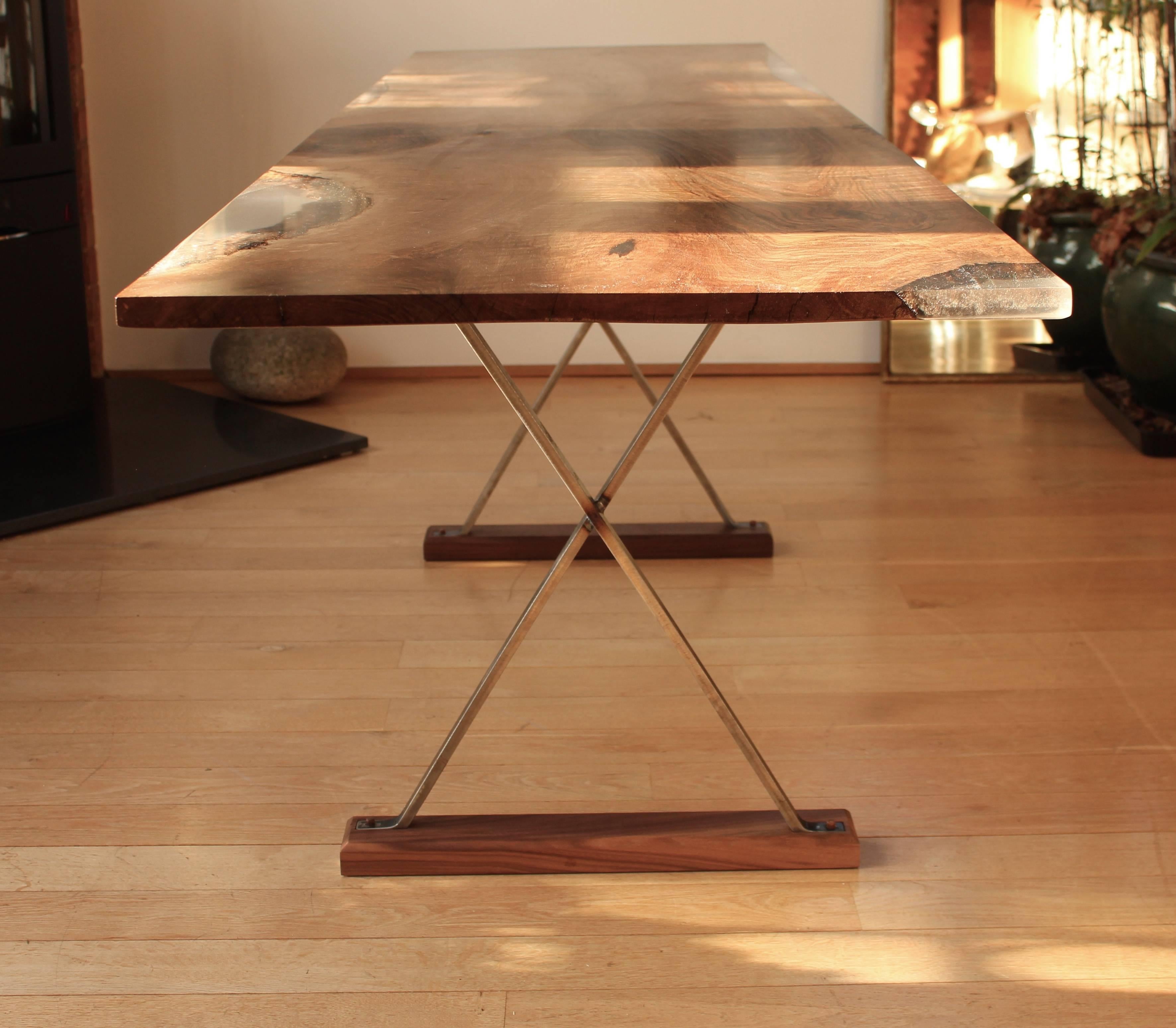 Ripple English walnut table with cross legs, the table is made from one piece of ripple English walnut with clear resin edge detail.

The raw steel cross legs are left unfinished with a wax coating. Walnut pegs hold the steel legs to the base