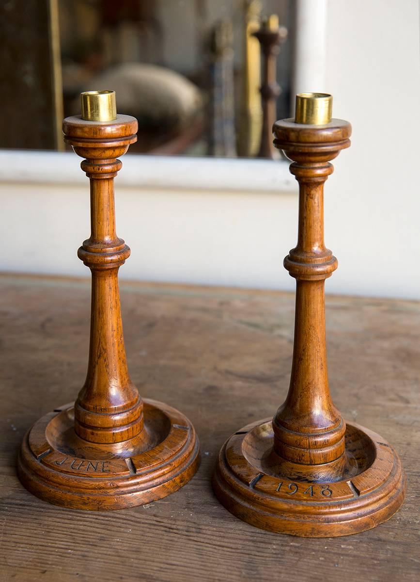A pair of turned oak commemorative candlesticks, one inscribed ‘June’ the other ‘1948’, both with original brass nozzles, of the post-war Arts & Crafts movement.