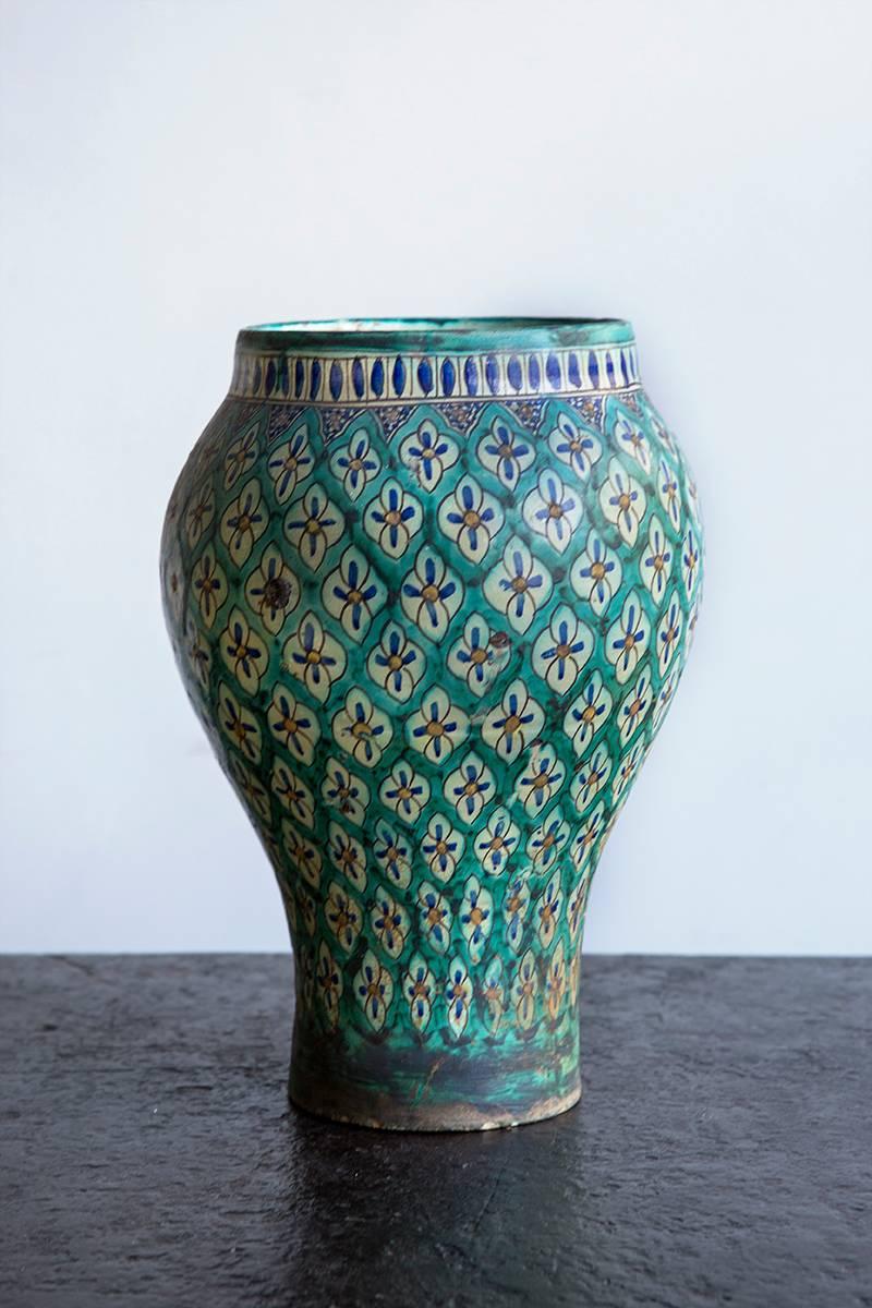Baluster shaped earthenware, the turquoise trellis ground embellished over the glaze with hand-painted blue and white flowers, circa 1930.