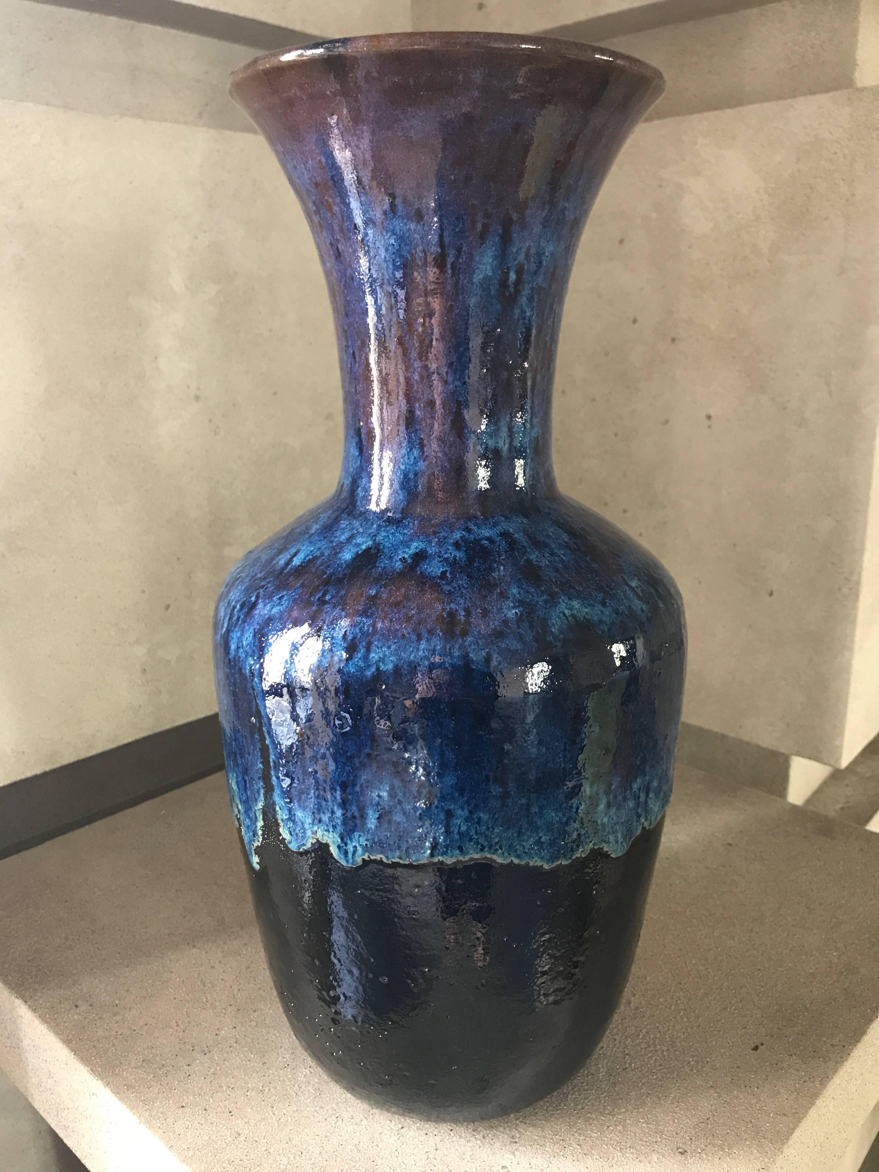 A handmade ceramic vase, classically inspired shape, in a dramatic cordovan, cobalt blue, and black custom glaze.
This stunning vase is suitable to be wired to become a lamp.
This contemporary vase has been custom designed and makes a sensational