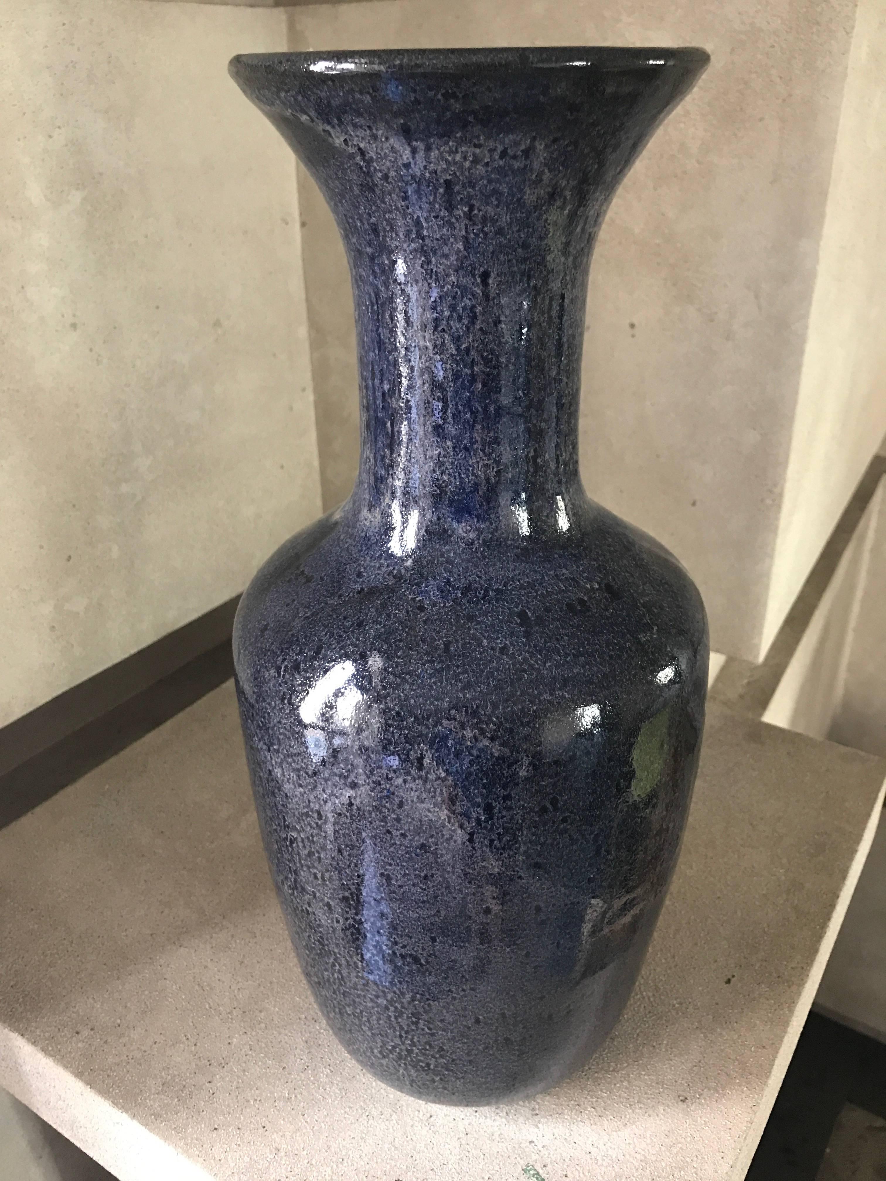 A handmade ceramic vase with a gracefully fluted neck in a custom lapis glaze with a deep blue-black undertone. 
This stunning vase is suitable to be wired to become a lamp. 
This contemporary vase has been custom designed and makes a sensational