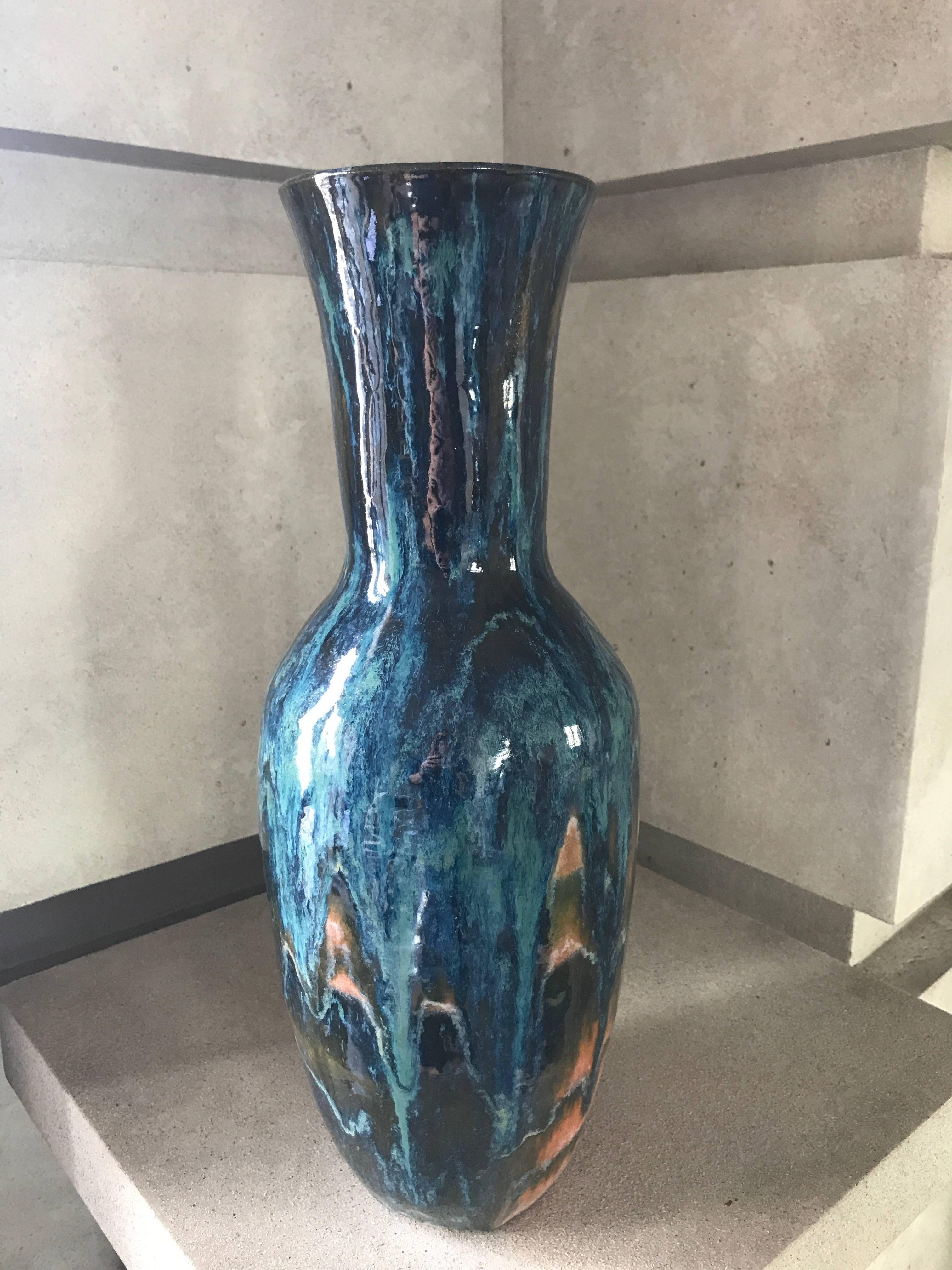 A handmade ceramic vase in a custom glaze featuring shades of navy, cobalt blue and apricot.
This stunning vase is suitable to be wired to become a lamp.
This contemporary vase has been custom designed and makes a sensational statement piece.