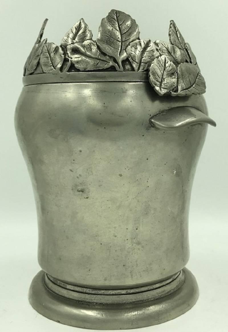 Exclusive and rare wine cooler by Dedalo, Italy
It is made up of two parts, the pot and a ring from a lot of bay leafs.

Hallmark with S, angel wings, Dedalo and 95% for tin.
