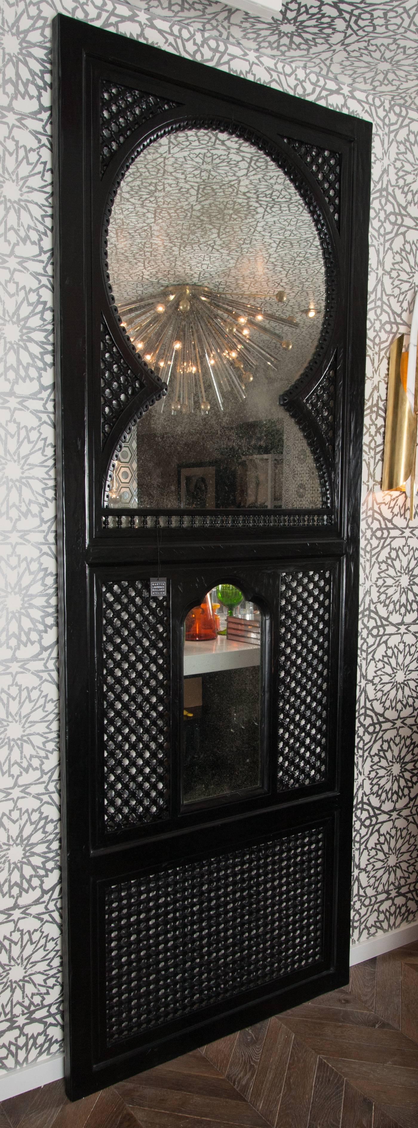 Martyn Lawrence Bullard's custom Agadir screen; taken from the window frames that line the walls of the King's palace.
Black lacquered alder wood with distressed mirror.