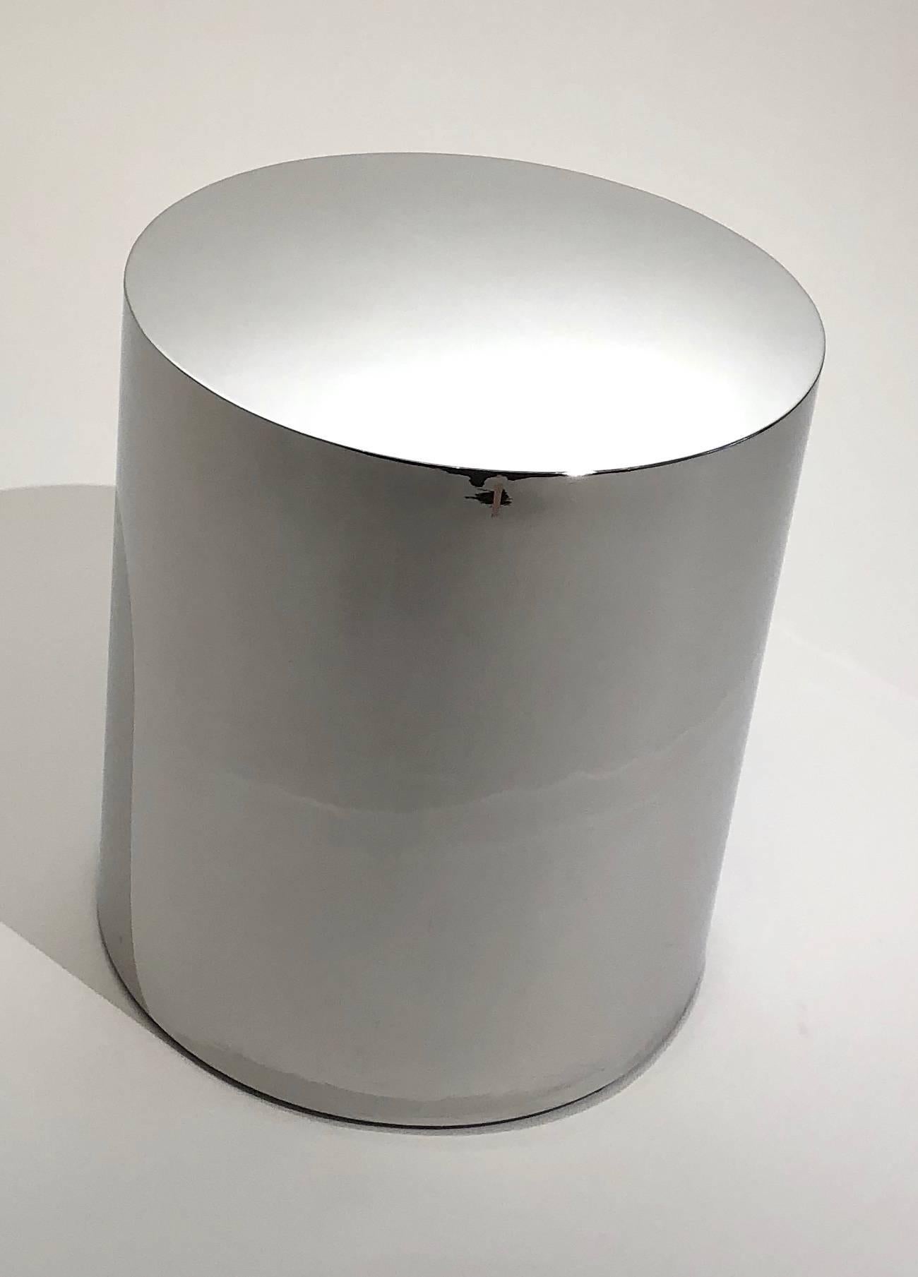 Seamless cylinder chrome side table with felt covered bottom.