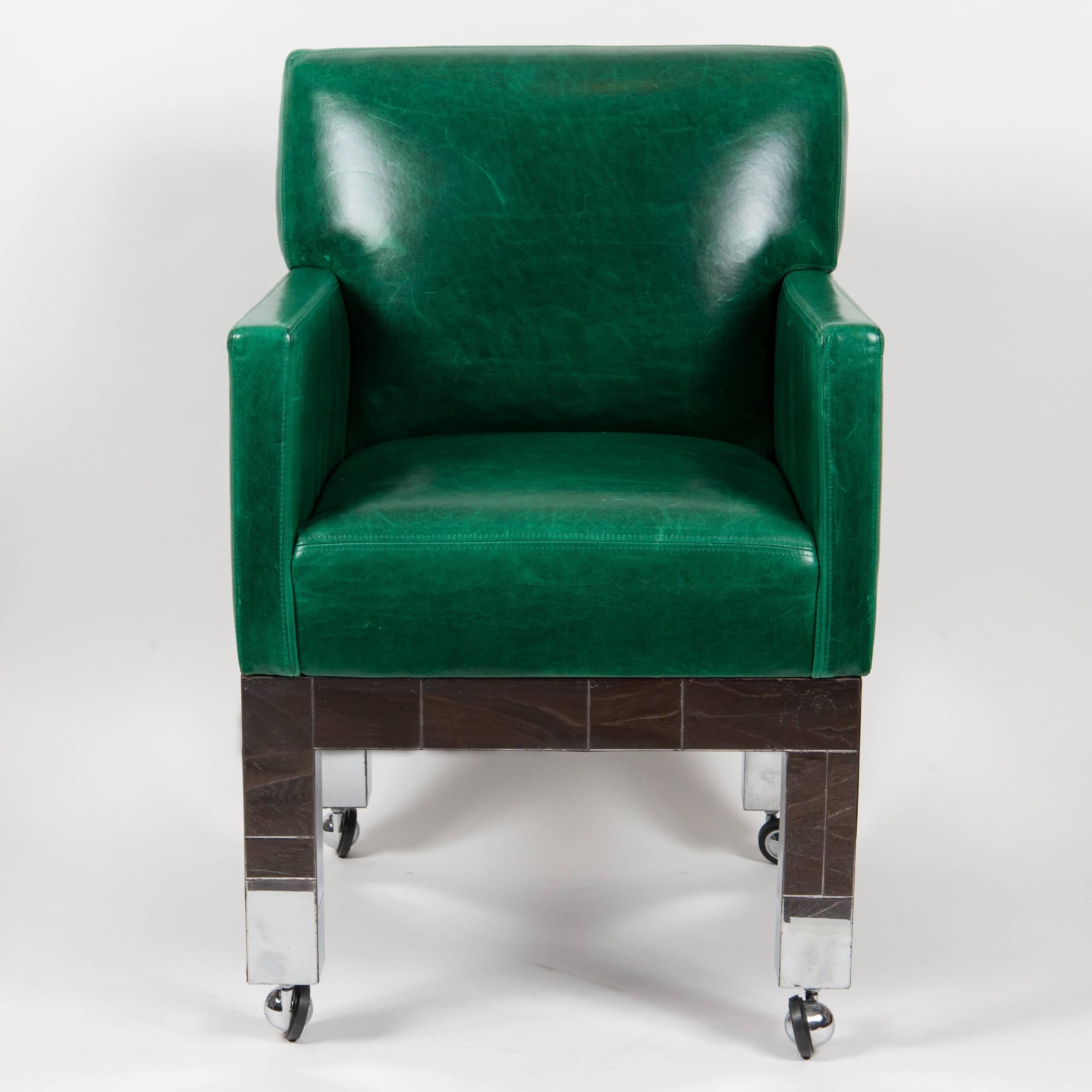 Pair of cityscape armchairs by Paul Evans in green leather and chrome base with rollers.
