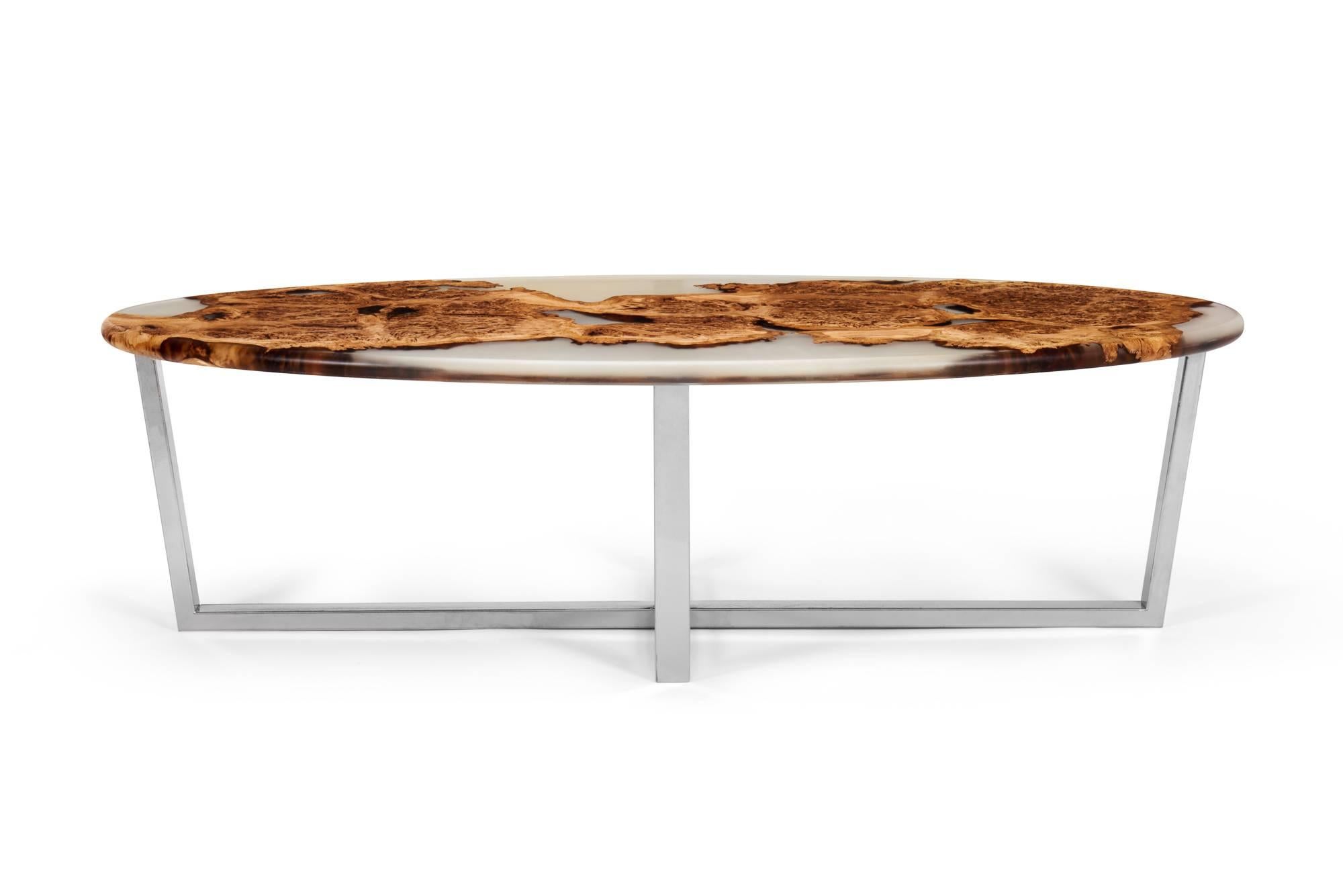 Beautiful oval coffee table made from English oak burr with rounded edge detail. The wood has been cast in clear resin to celebrate the live edges and knots in their full glory. This piece sits on a steel base with a chrome powder coated finish.