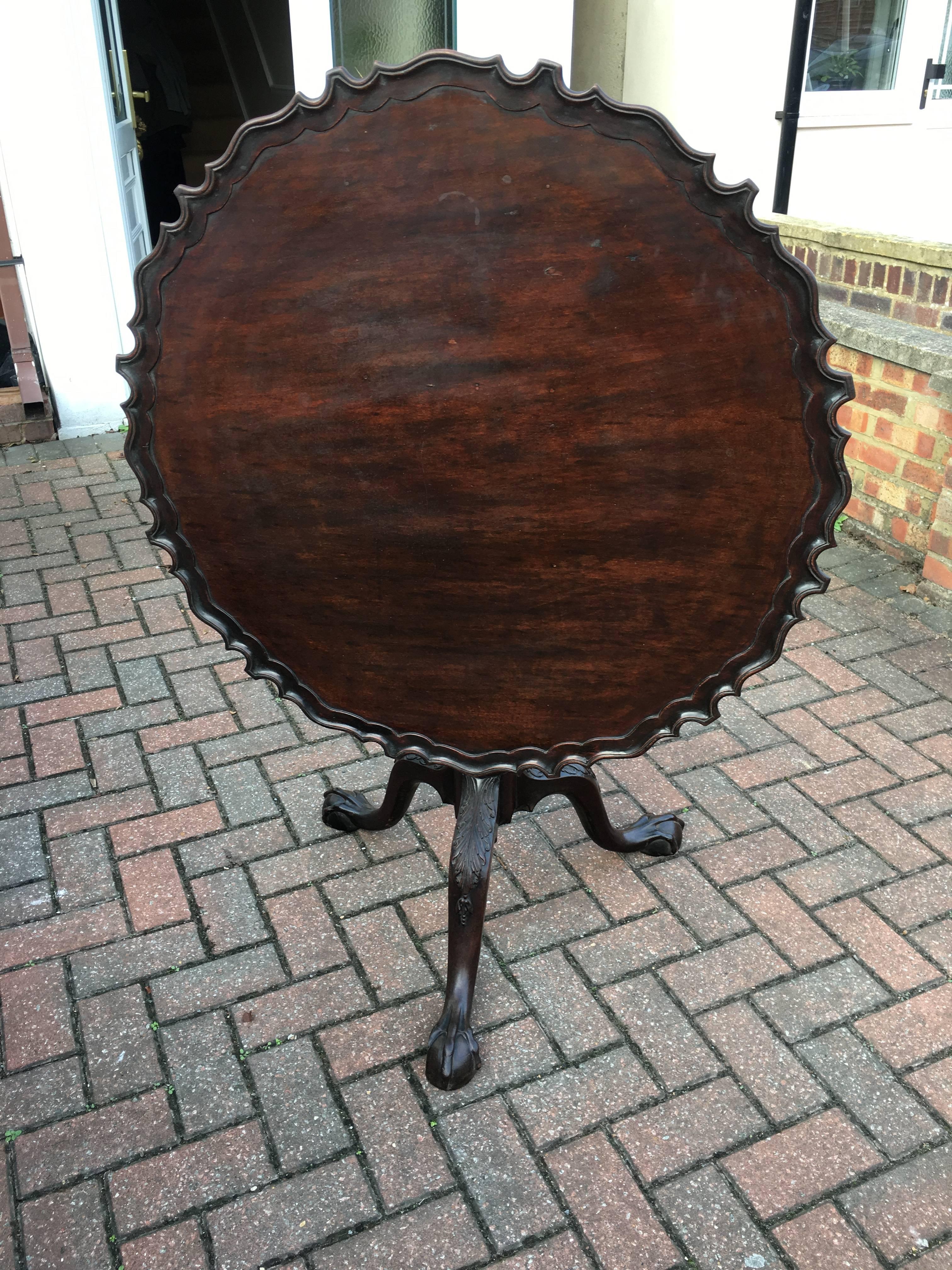 A GEORGE III PERIOD C1760 MAHOGANY TILT TOP TEA TABLE The circular piecrust top with birdcage, raised on a cannon and twist pedestal column with three acanthus carved splayed legs, terminating on ball and claw feet. 

