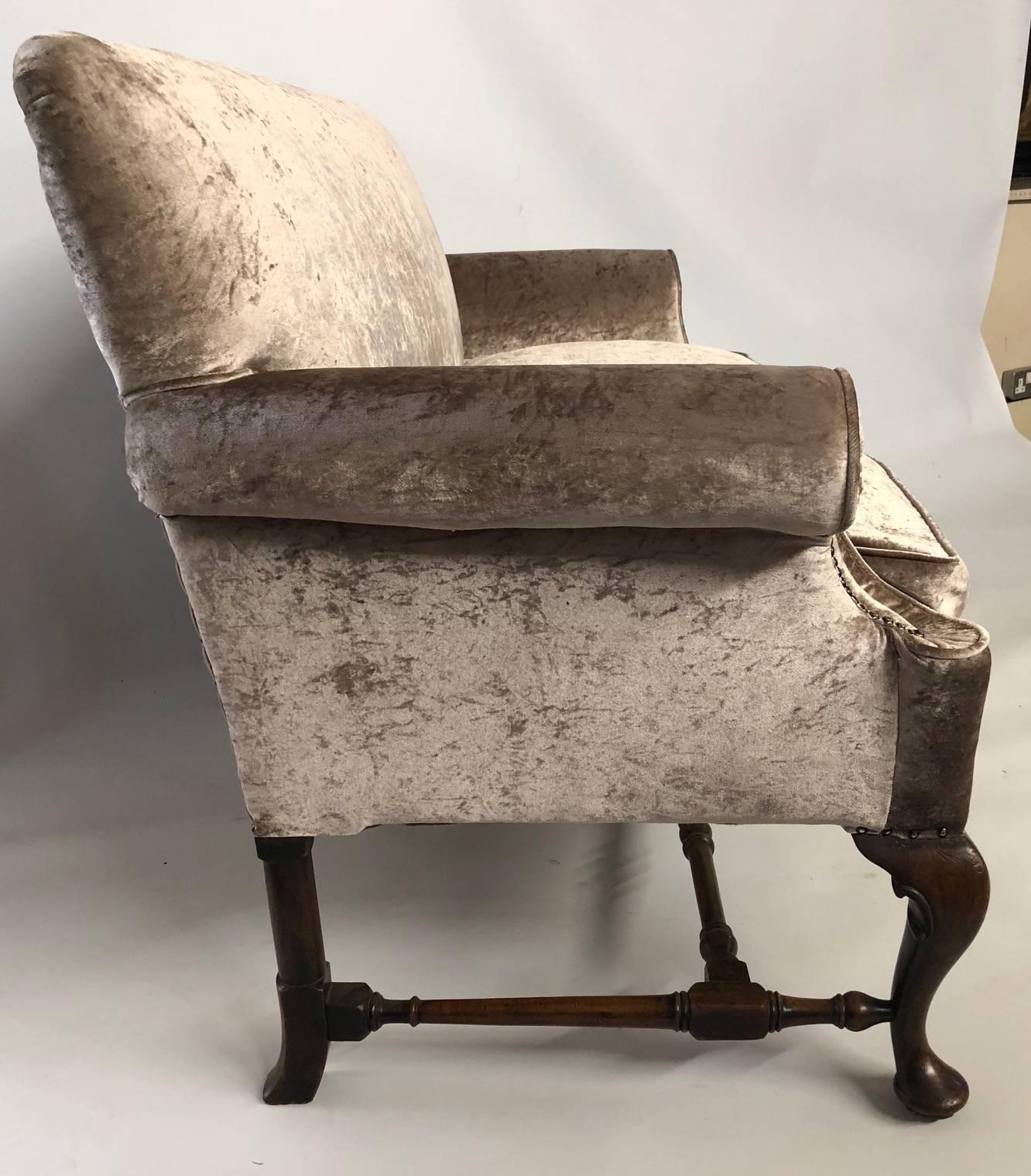 Trollope & sons, a 19th century walnut George I design crush velvet settee. 
The straight back over scrolling arms, raised on three carved cabriole legs joined by a double turned H stretcher. 
(w 158cm x d 68cm x h 92cm)