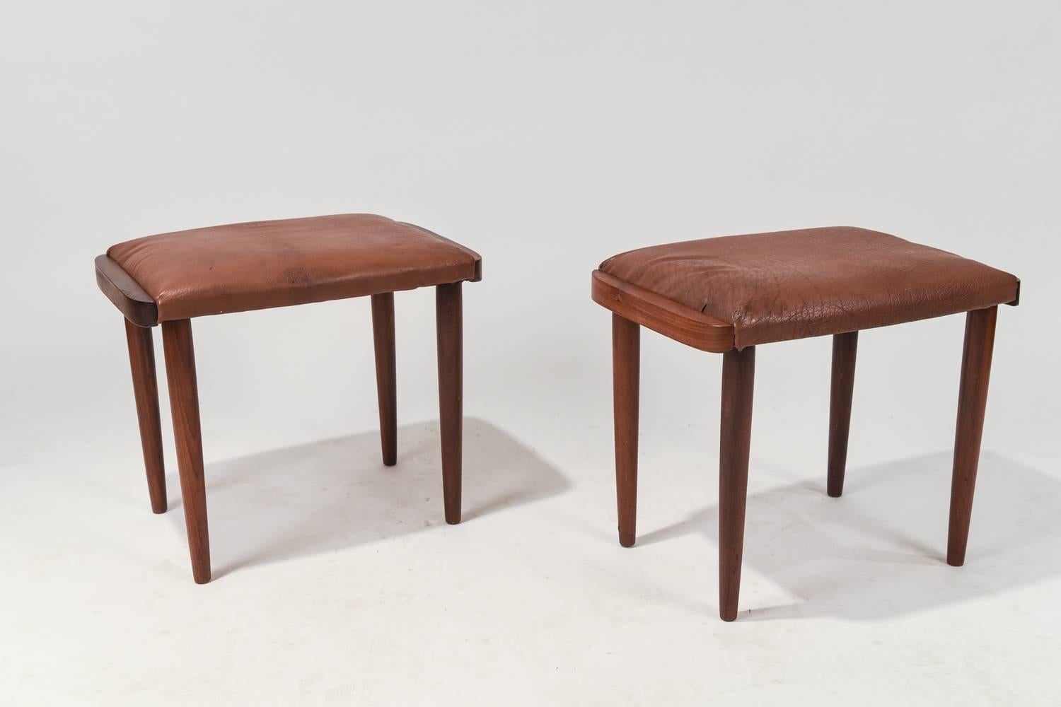 A stunning pair of Danish Mid-Century stools made of teak and upholstered with leather. Provides great extra seating.
