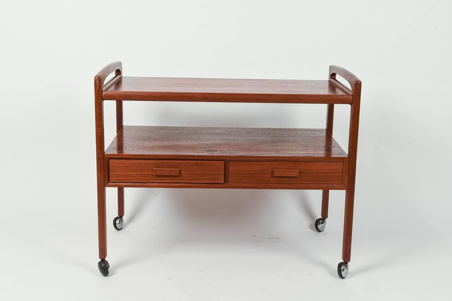 This Arrebo Møbler teak bar / tea / serving trolley has wonderful proportions. It features two drawers, a perfect storage spot for cocktail napkins or coasters.