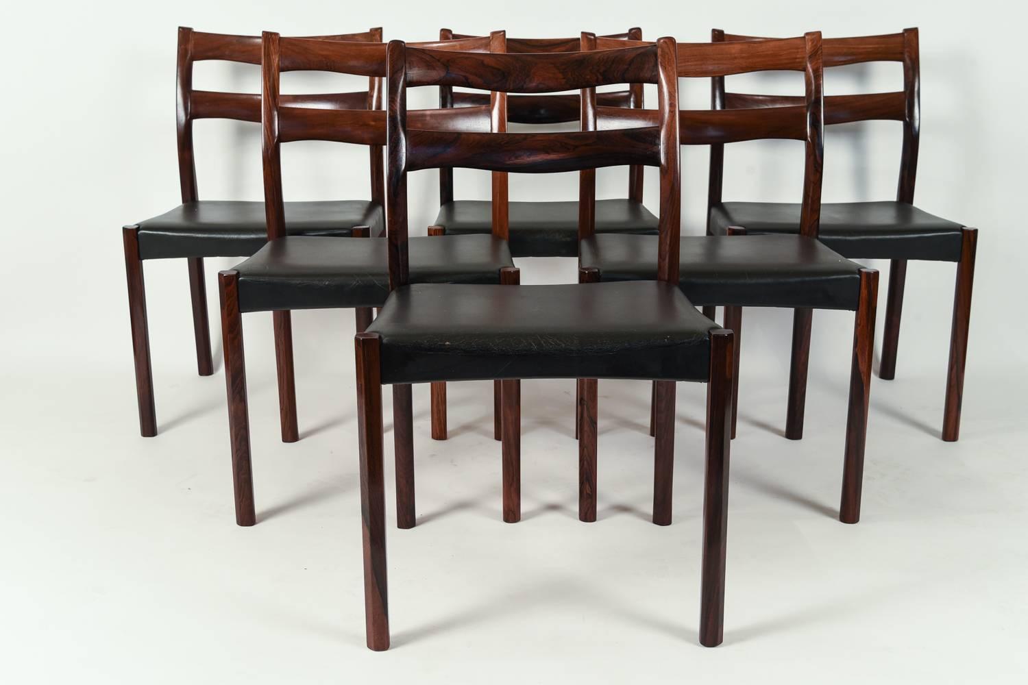 A beautiful set of six side or dining chairs in the style of Ole Wanscher. Made of rosewood and upholstered in black leather.
