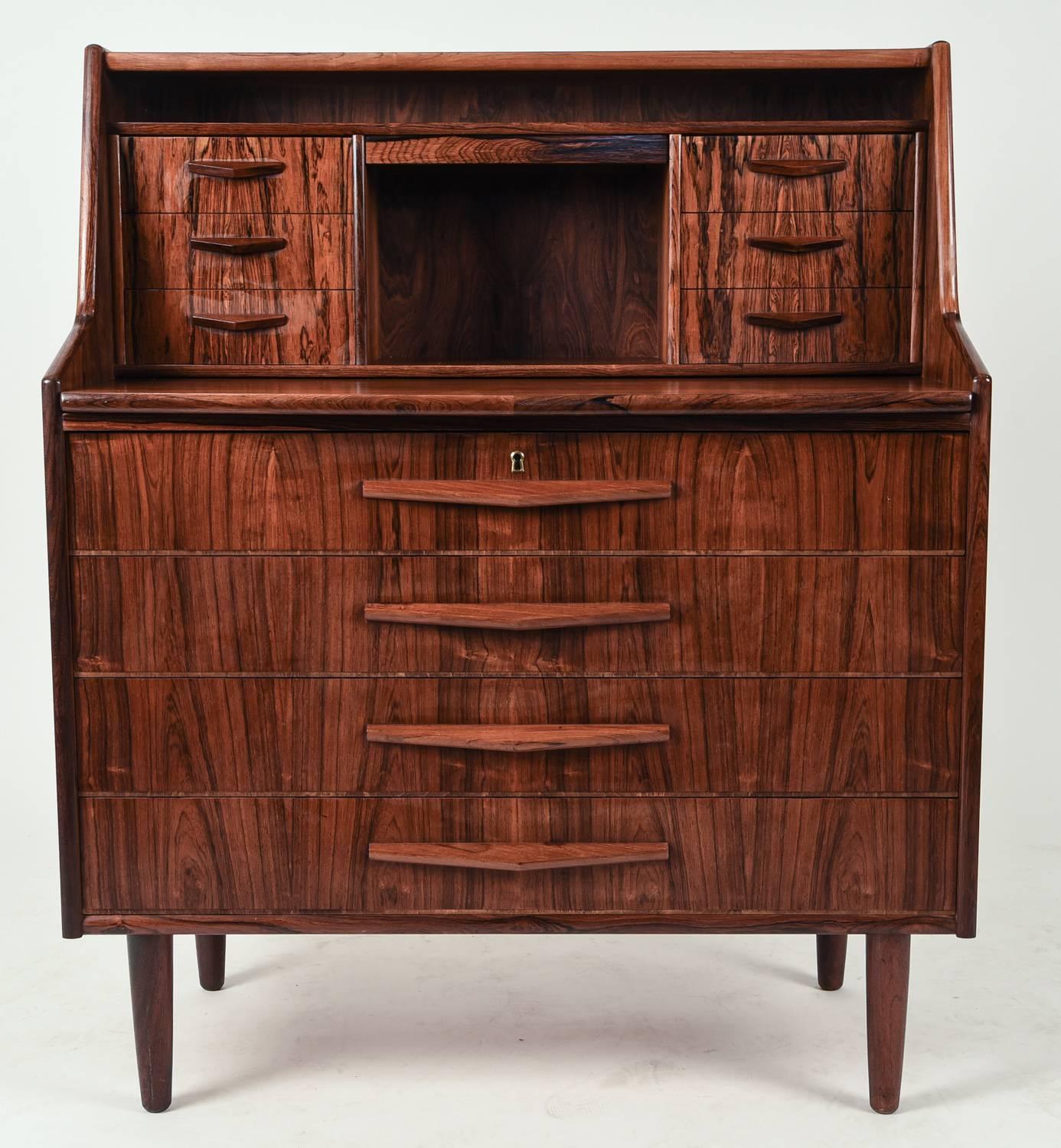 This Danish Mid-Century secretary is made of handsome rosewood and features three larger drawers on the lower half, and a niche surrounded by two sets of three drawers on the upper half. Would make a great vanity or chest for a bedroom, or could be