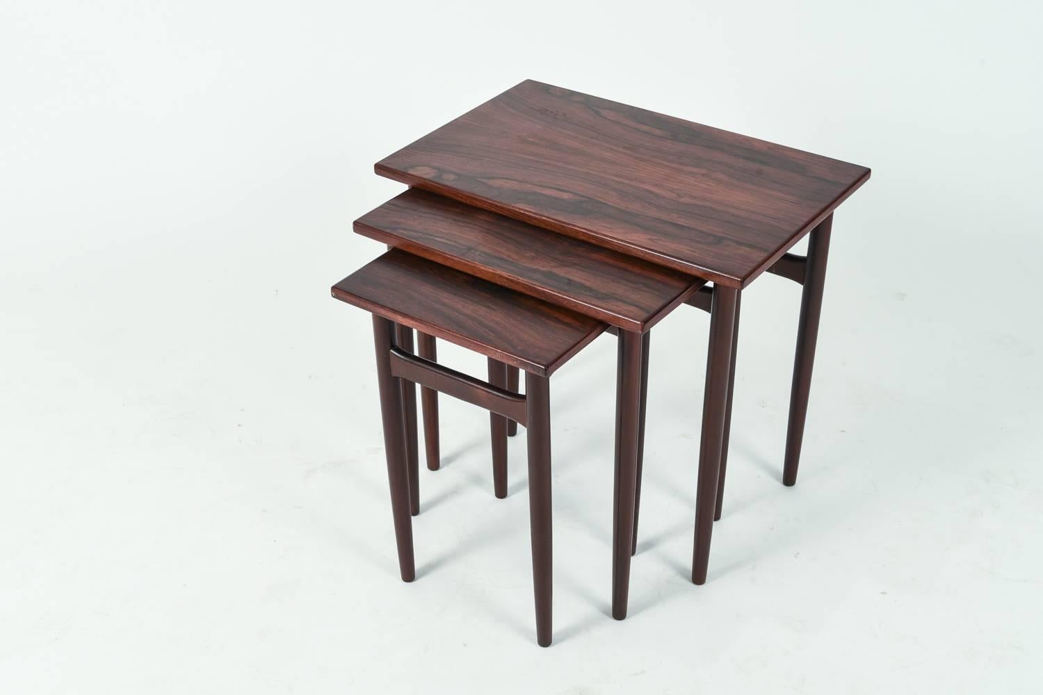 This is a beautiful set of three Danish Mid-Century nesting tables in handsome rosewood.
