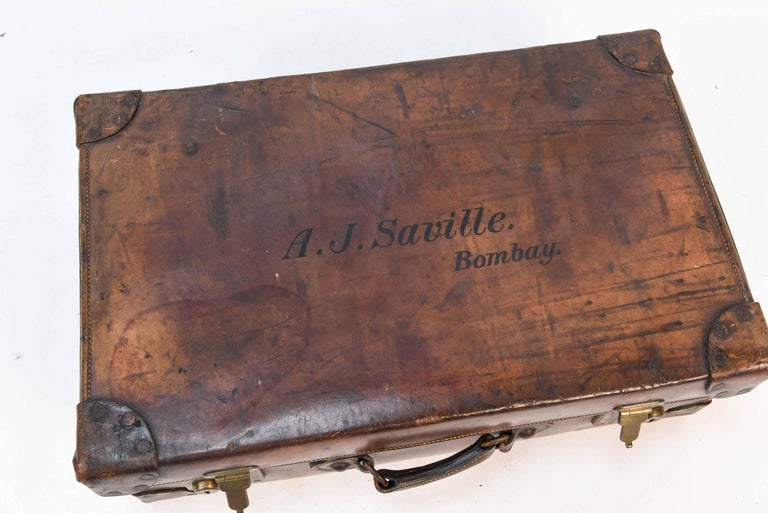 This vintage leather luggage case is a charming piece due to its age and wear. The side reads 
