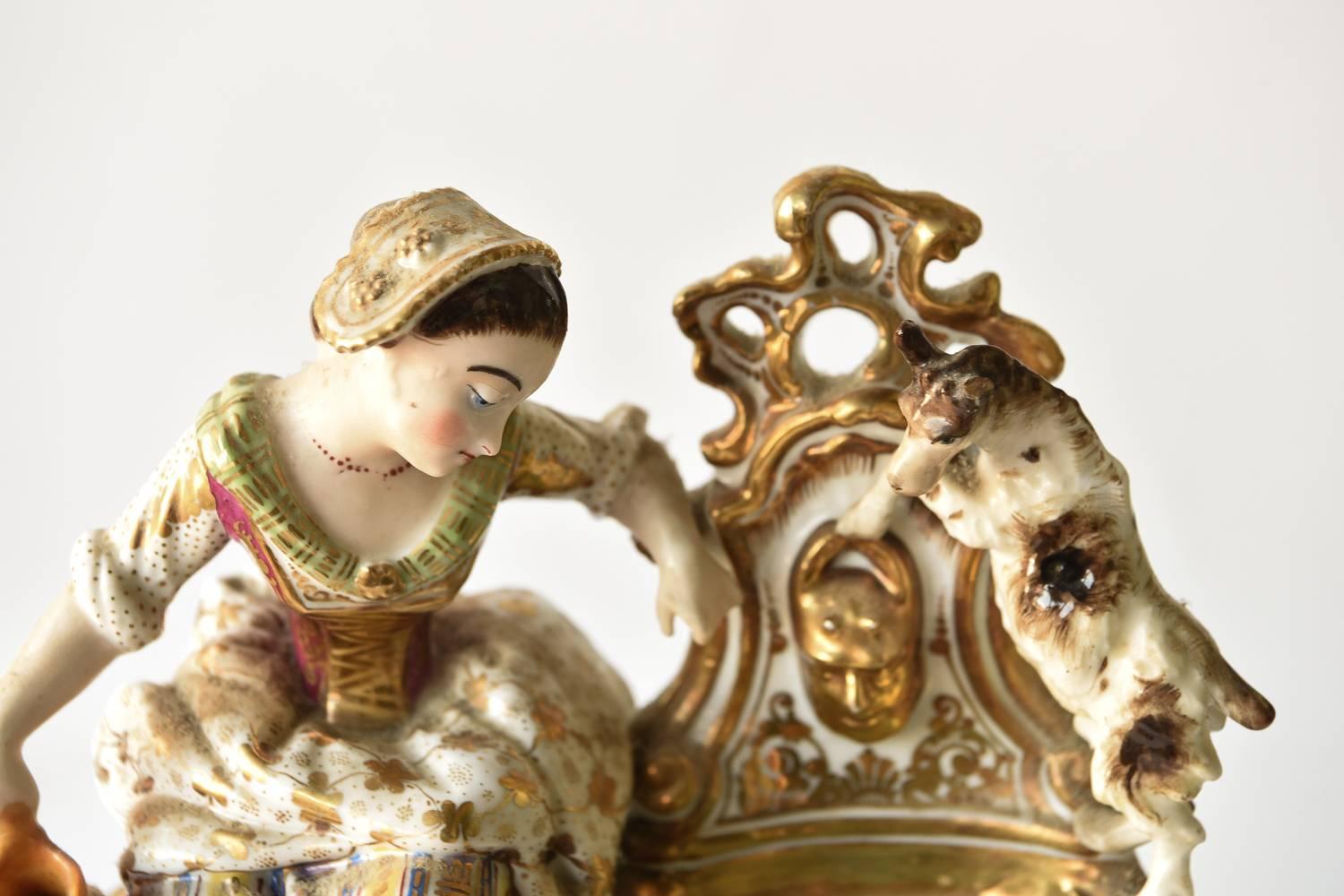 Diese französische Porzellanuhr stellt ein Bauernmädchen dar, das mit seinem Hund Wasser holt. Die Uhr besteht aus zwei Teilen. Von Jacob Petit. Der Sockel ist charakteristisch für das Rokoko und trägt zum extravaganten Erscheinungsbild bei.