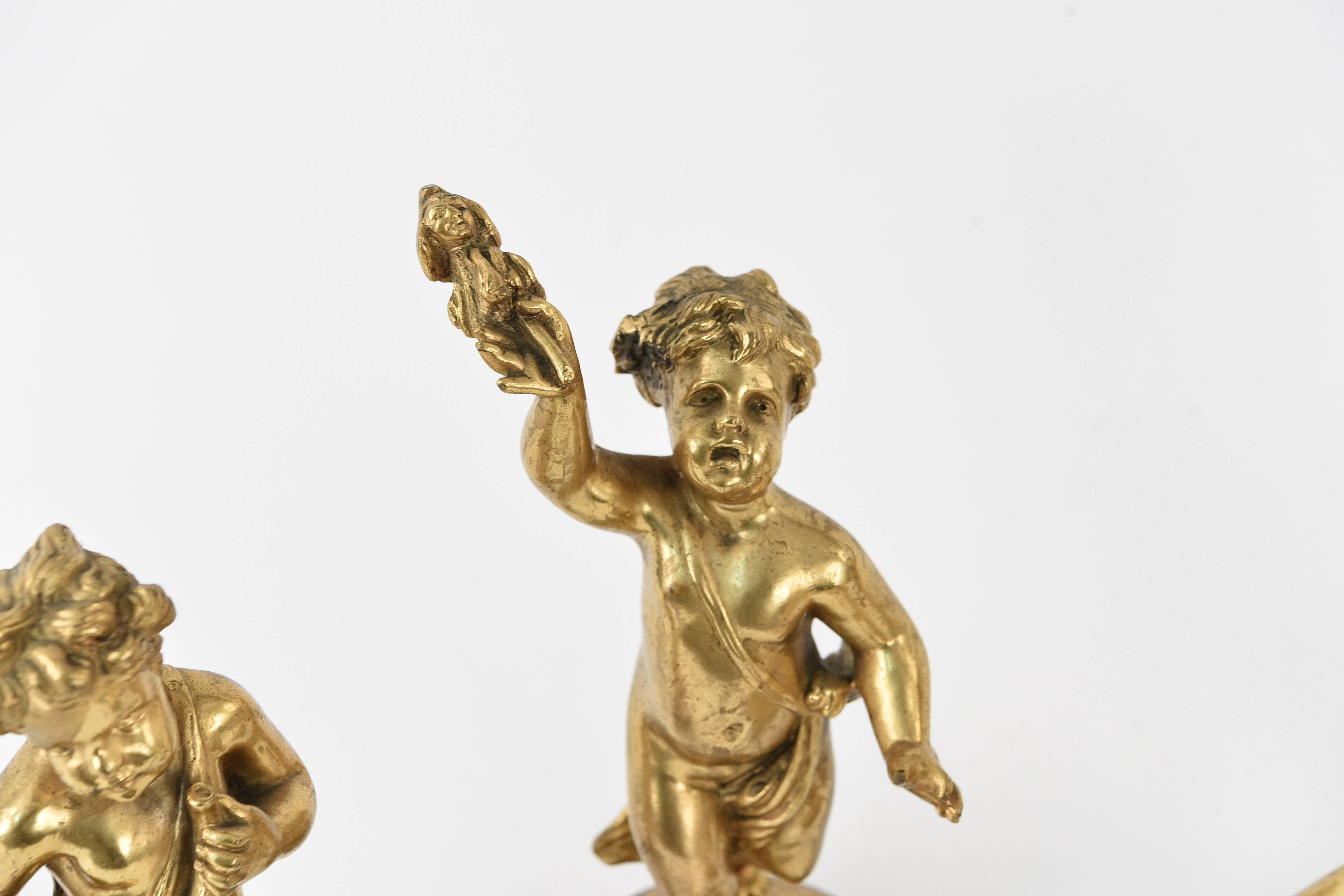 Signed illegibly. These precious gilt bronze cherubs are depicted playing instruments. The set can be used together to create a charming scene, but each piece is able to be used on its own as a beautiful little sculpture. These would be a fun