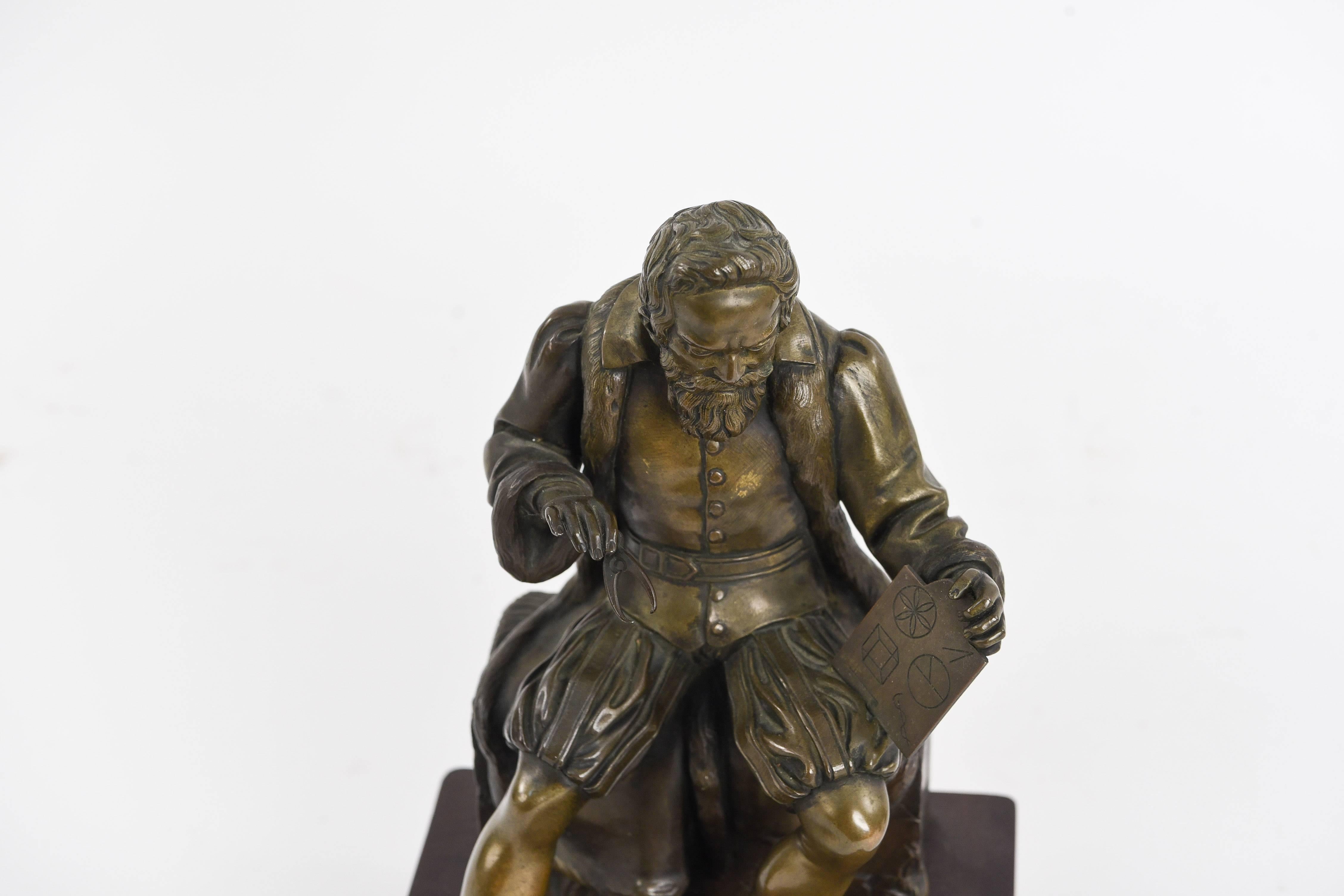 This French bronze is signed illegibly and marked Paris to the back. It depicts a mathematician, as shown with his tools. This well crafted piece sits upon a wooden base with green felt underneath. Very beautiful sculptural detail in the clothing