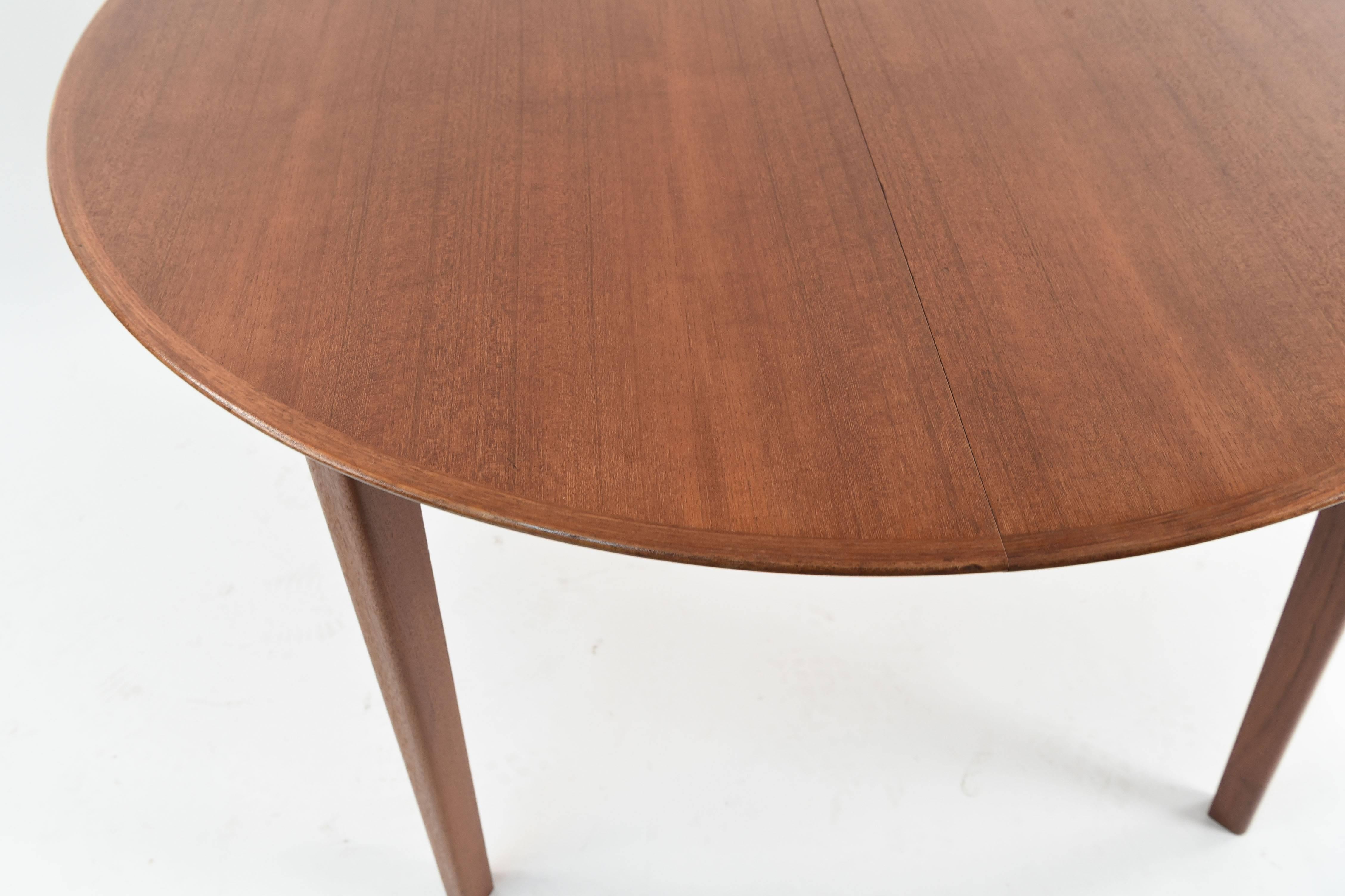 All restored very beautiful round dining table with beveled edges greatly designed by Ole Hald for Gudme Møbelfabrik. Superb quality and excellent condition.

Measures 48 inches in diameter with one extension that can make the table a total of 86