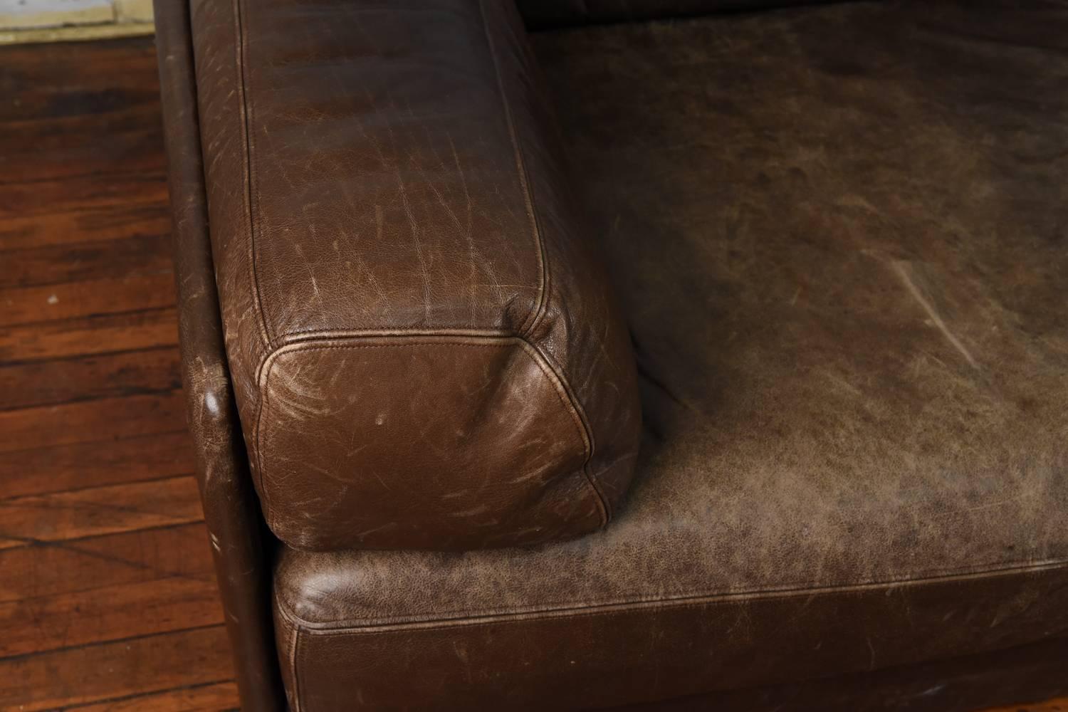 This sofa is made of two pieces which can be combined to make one loveseat, or can be separated to make two lounge chairs. The perfect piece for rearranging a room's layout for entertaining purposes. A great warm and perfectly distressed leather