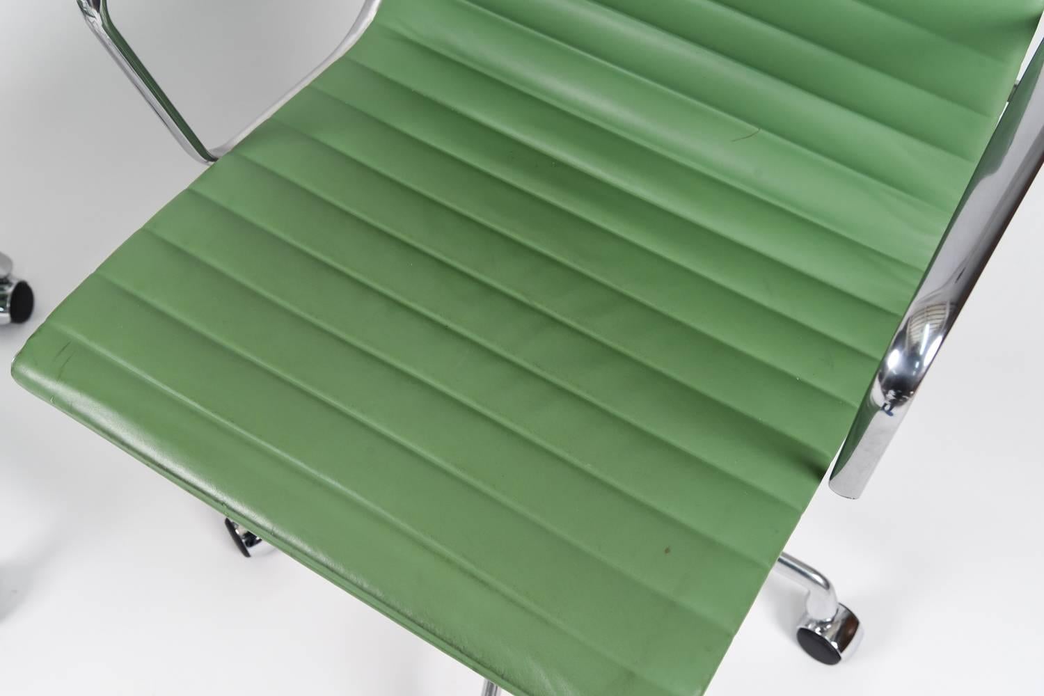 Eames Aluminum Group chairs were developed in 1958 by Charles and Ray Eames for a home designed by Eero Saarinen and Alexander Girard. These are a stunning pair in rare apple green leather produced by Herman Miller in the late 20th century these two