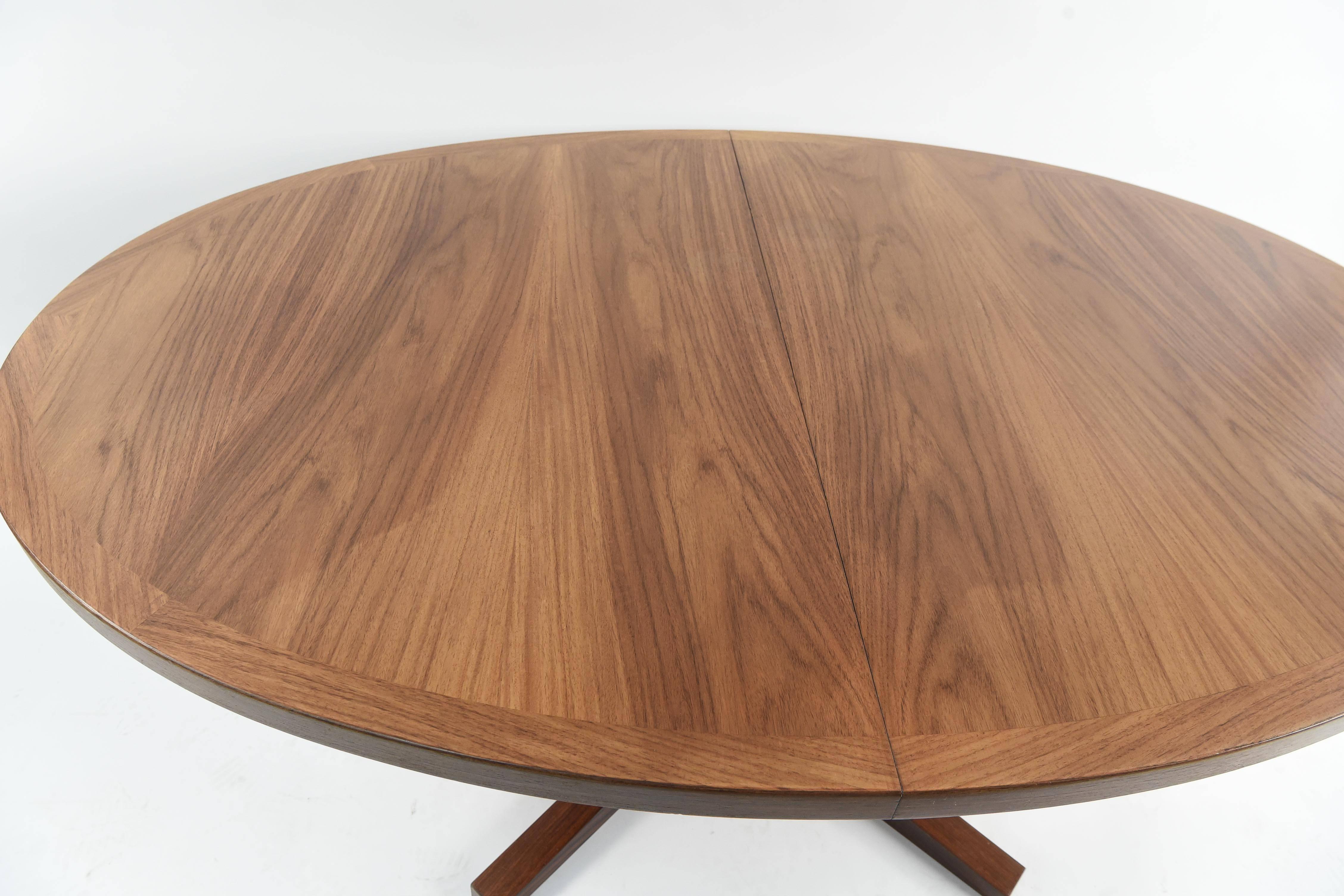 This oval dining table has been crafted from fine rosewood and includes two leafs to extend the table to accommodate more guests. Designed by John Mortensen, this table has a sturdy, elegant form. Manufactured by Heltborg Møbler. Each leaf adds 19.5