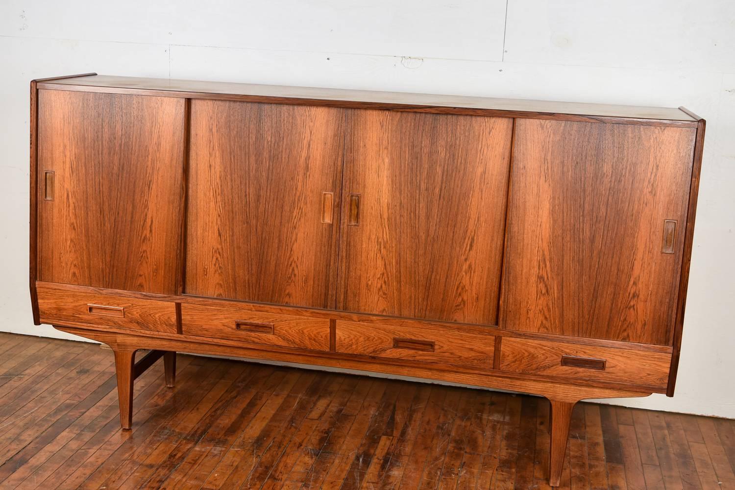This Danish midcentury highboard features beautiful rosewood with four drawers and four doors.
