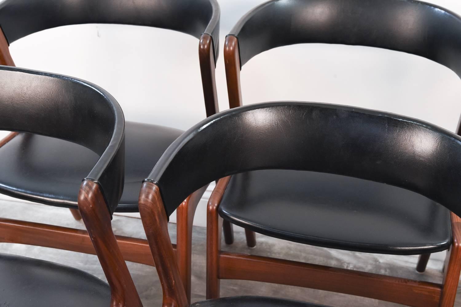 This set of six side or dining chairs was designed by Danish architect Oman Jr. in the 1960's. Wonderful teak frames with original back and seat upholstered in black skai. Very interesting form.
