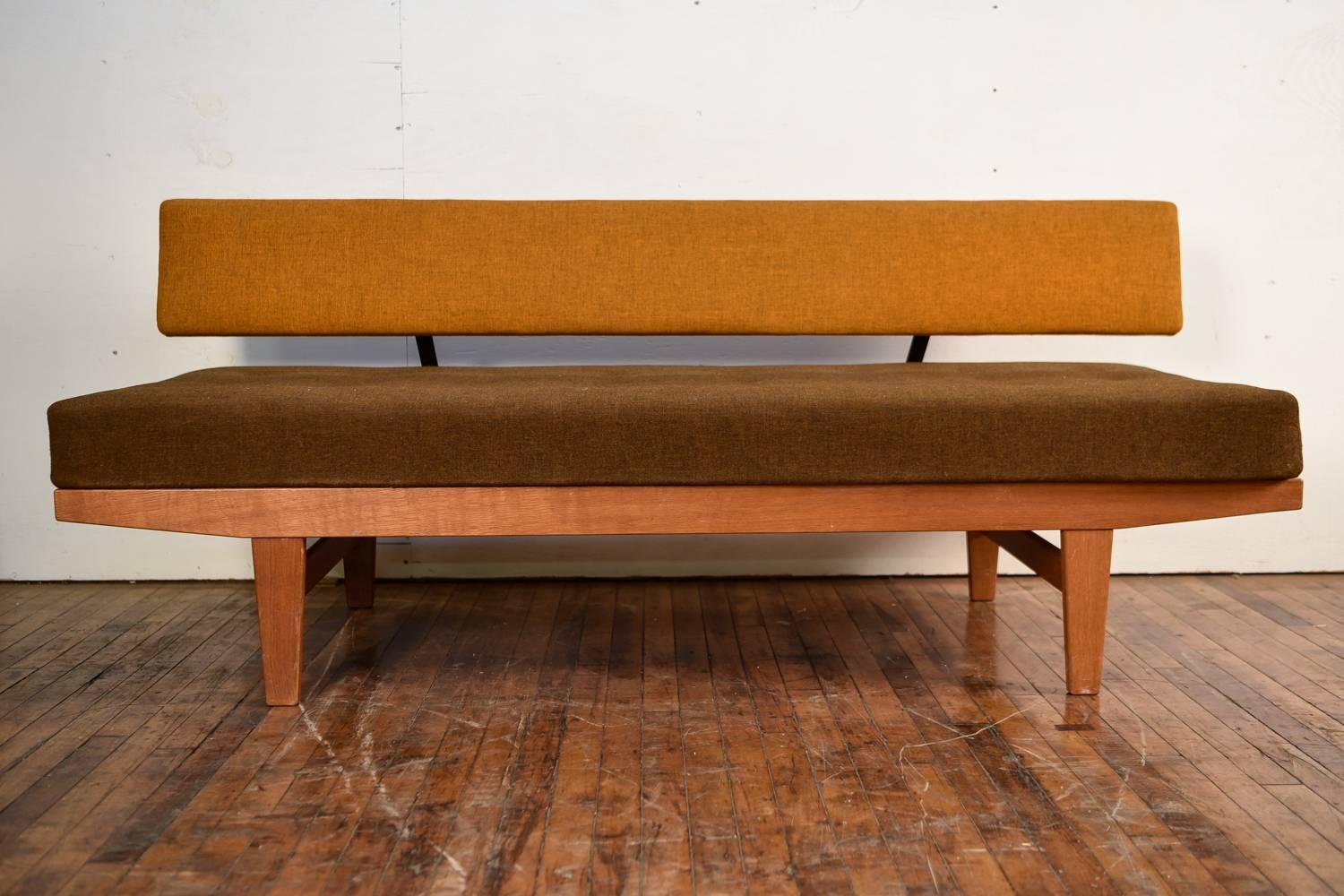 A Danish midcentury teak daybed designed by Poul M. Volther in 1958. Manufactured for FDB by C. M. Madsen, Model H9. Model H9 is notable due to the removable backrest, really allowing it to transform from a sofa to a daybed. The tufted seat is most