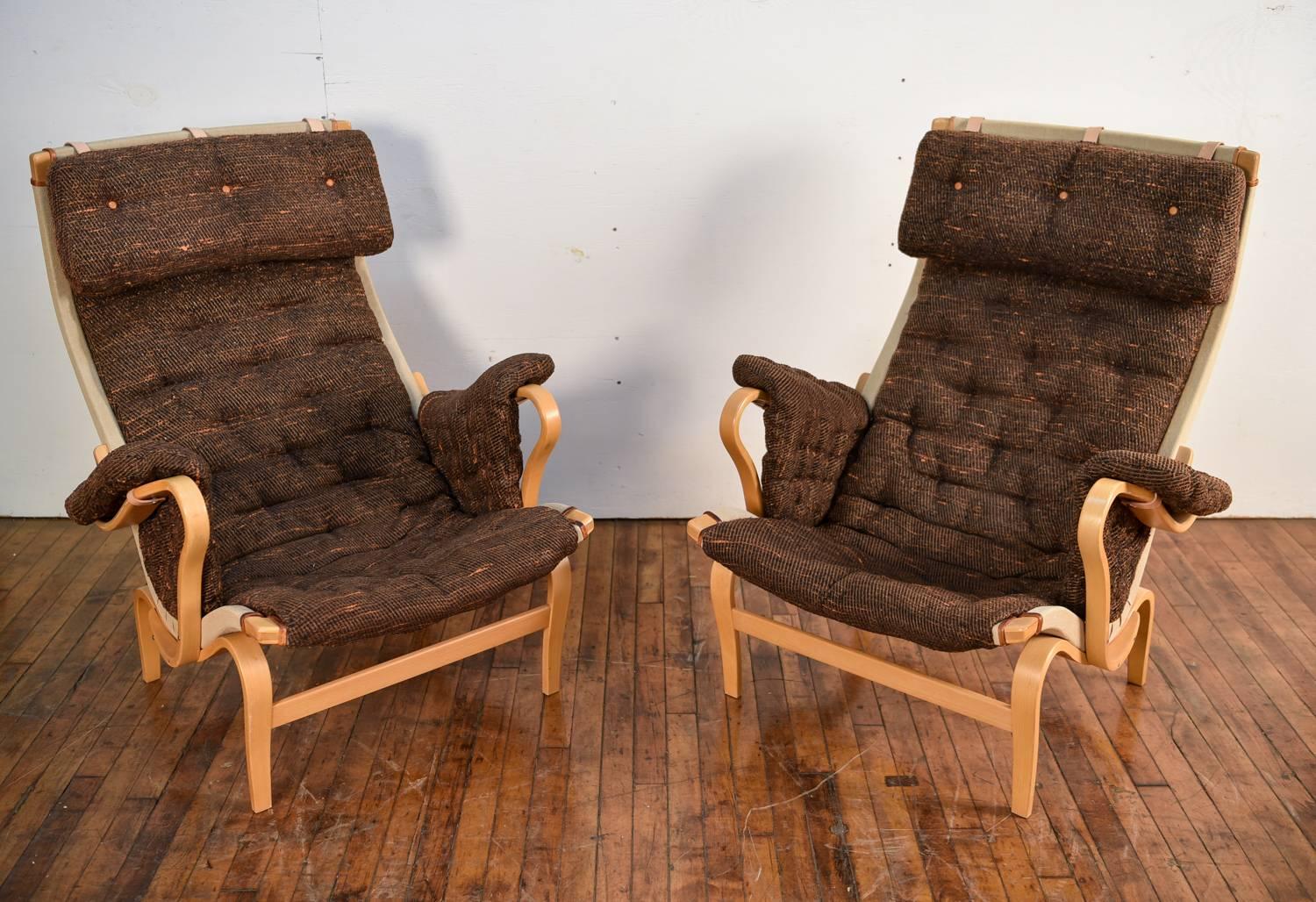 A pair of 'Pernilla' lounge chairs designed by Bruno Mathsson and produced by DUX in 1969. These chairs are notable for their wavy bentwood frames, which provide for a unique, visually interesting form. Upon these frames sit cushions that extend