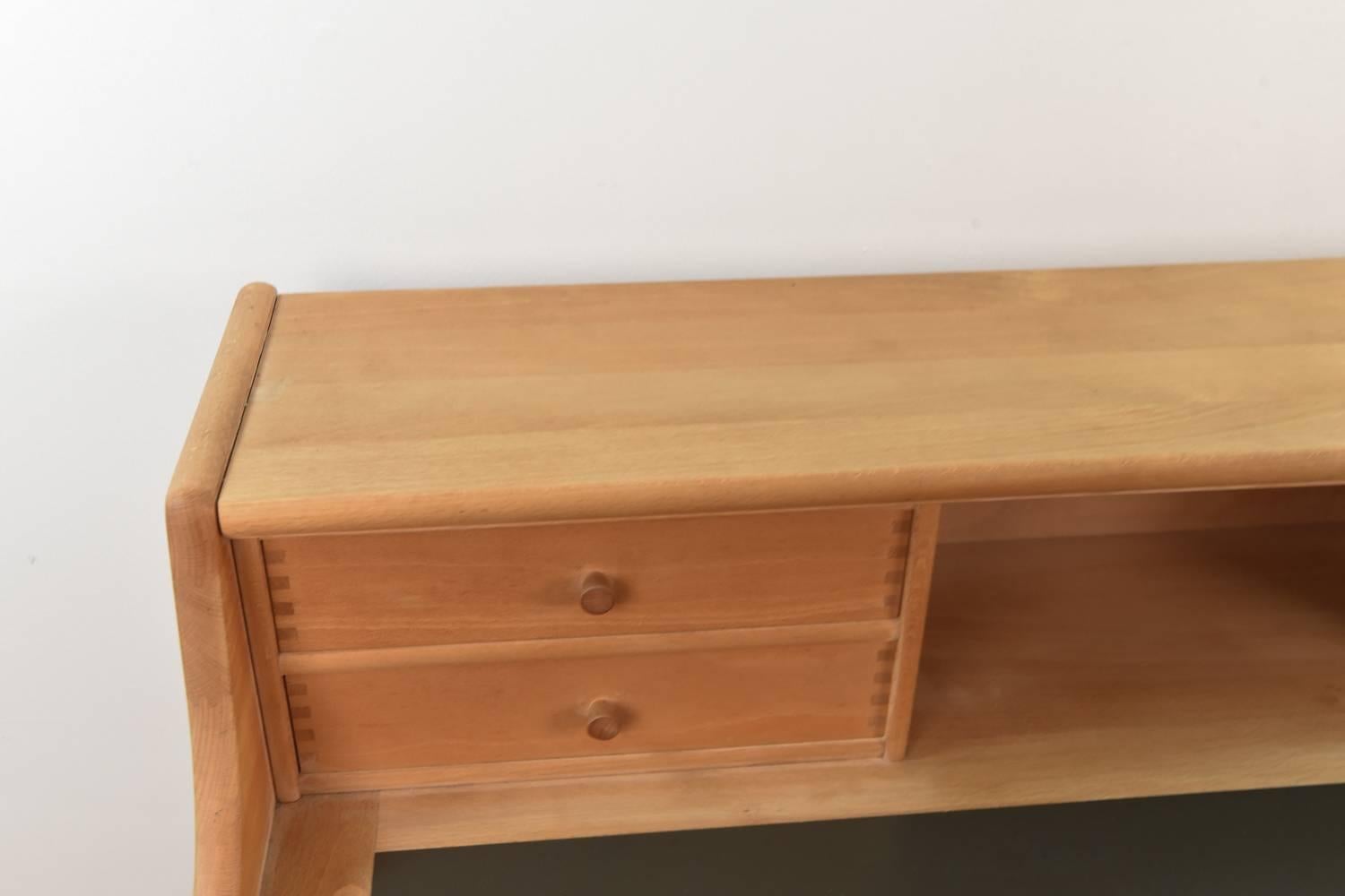 This model 50 desk by Andreas Hansen features an inset leather writing top and a frame of beech wood. There are two larger drawers underneath and four smaller drawers and a compartment above, providing great storage and organization spaces. Would be