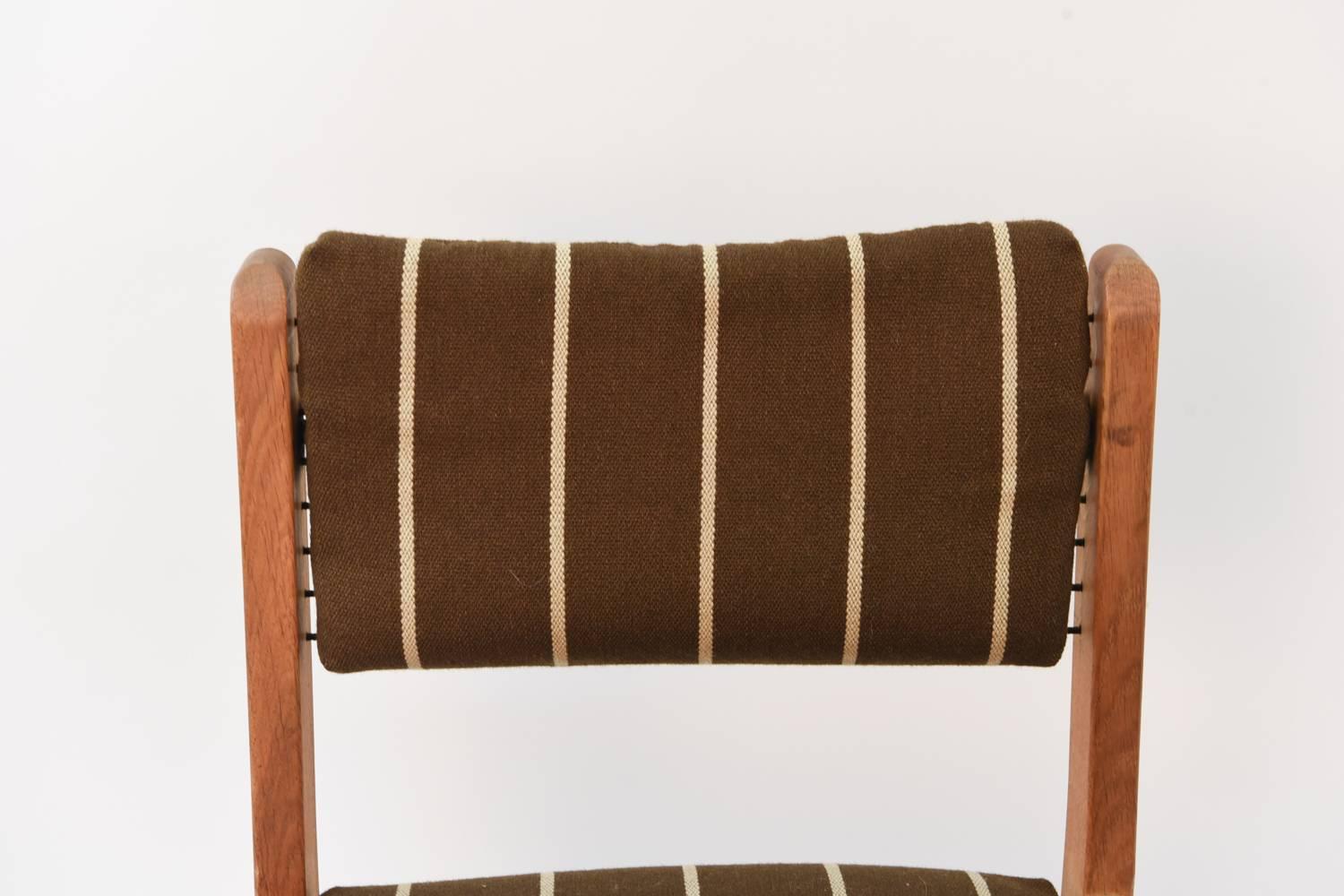 A set of six Danish midcentury side chairs featuring oak frames with flagline cording to support the back and seat cushions. A great set with interesting form.