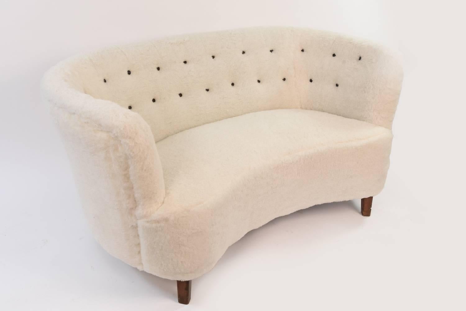 This incredible banana loveseat or two-seat sofa by Slagelse Møbelværk has been recently reupholstered in lambs wool and features a wonderful tufted backrest with contrasting black tufts. Classic, highly coveted form in exquisite upholstery.