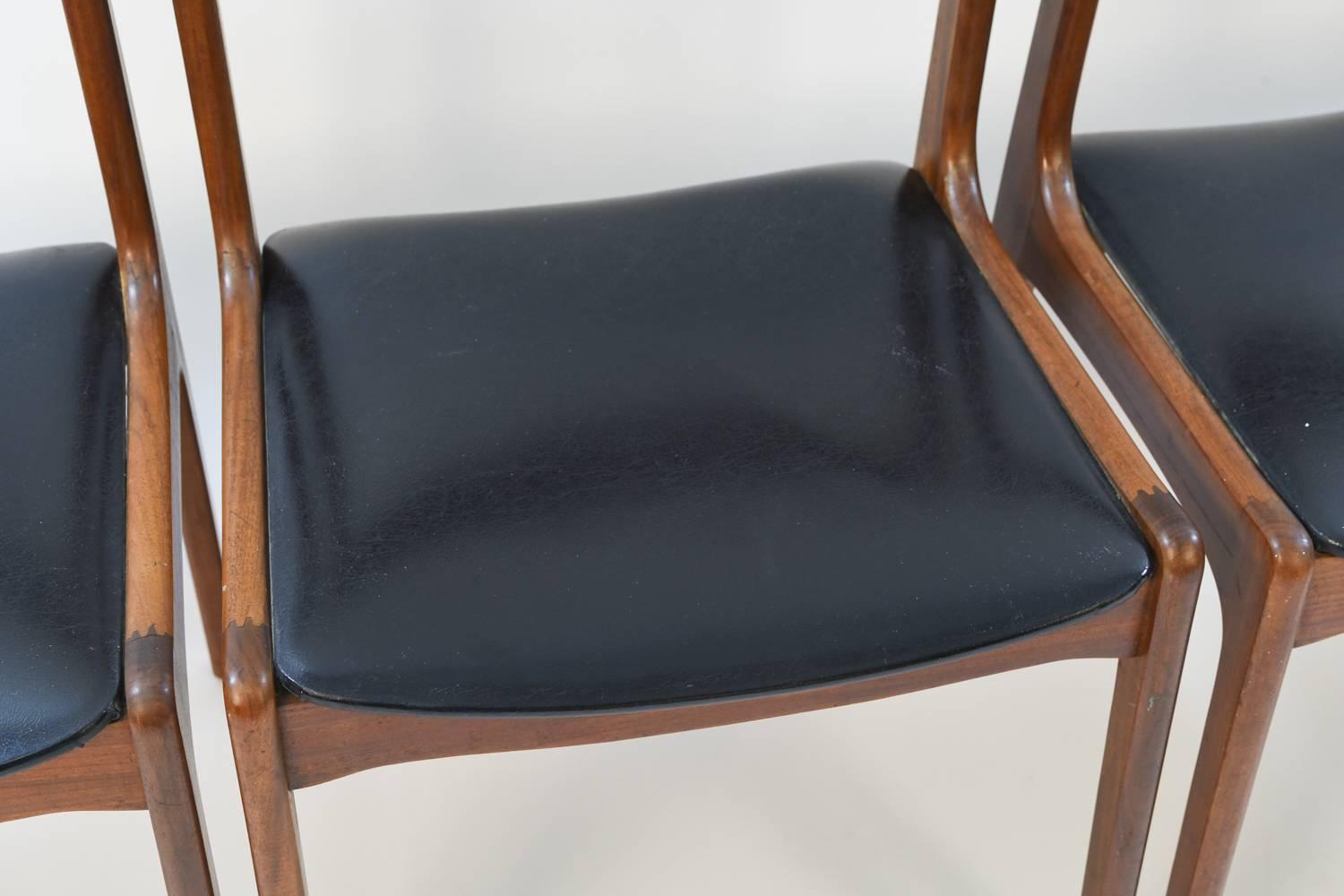 This set of four Danish midcentury side chairs features handsome teak frames and black seats. Subtle angles provide more visual interest in an otherwise classic, simple form. These could be great extra seating in a living space or around a kitchen