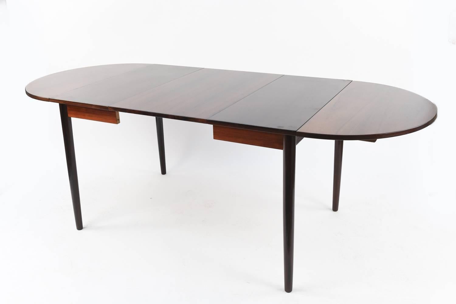 This is a stunning Danish mid-century dining table made of rosewood with a handsome color and grain. Multiple leaves allow for easy extension to accommodate guests. The table with all four leaves installed opens to 102.5" wide.