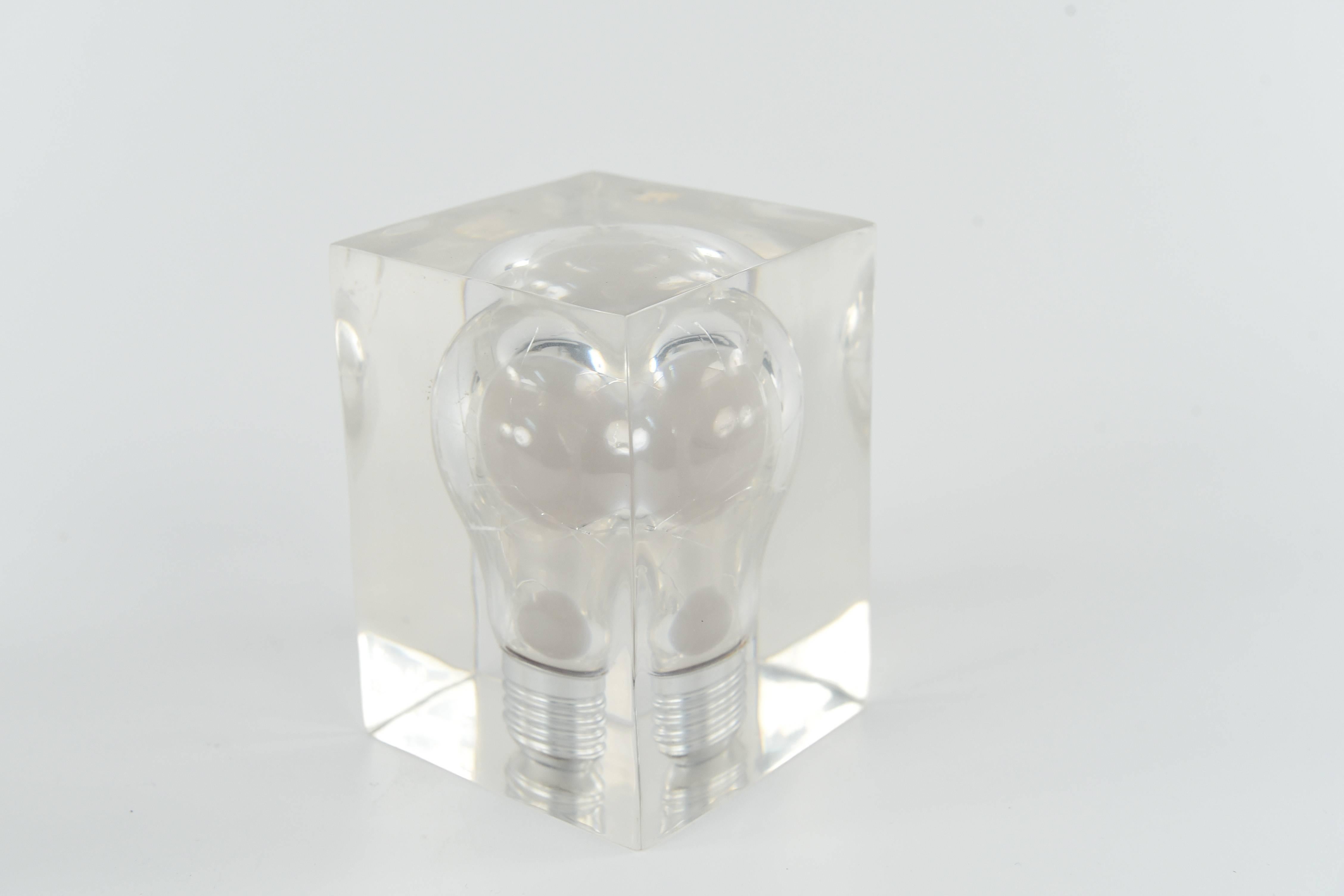 A very interesting light bulb suspended in a Lucite cube, a very cool decorative accent to any shelf or table.