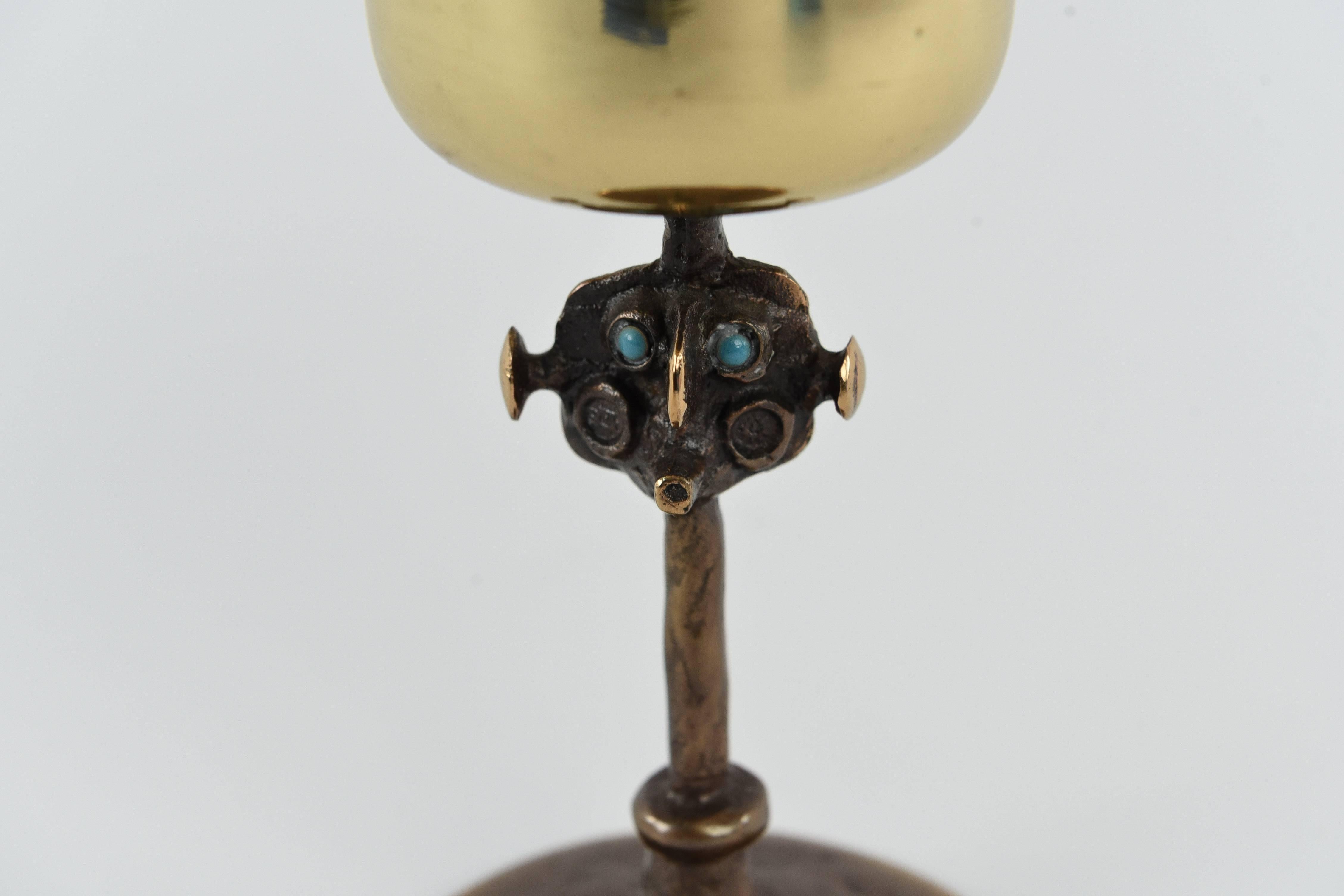 A whimsical brass sculpture of a figure with face and blue eyes. Handmade, circa 1970s.