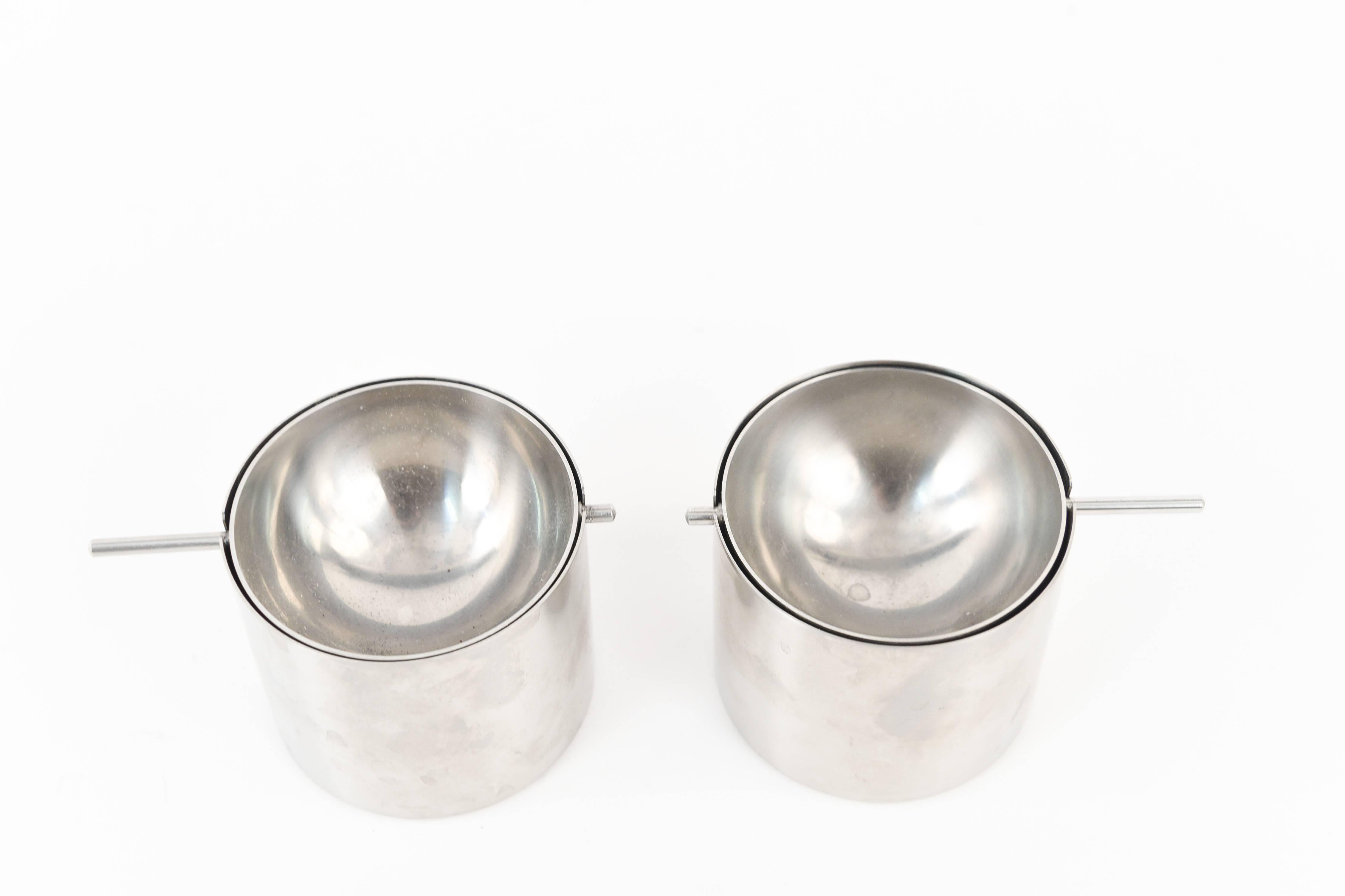 These ashtrays are an iconic form by Danish designer Arne Jacobsen for Stelton. From the Cylinda Line, 1967. They feature a revolving top, with a sleek midcentury chrome look. Two available.