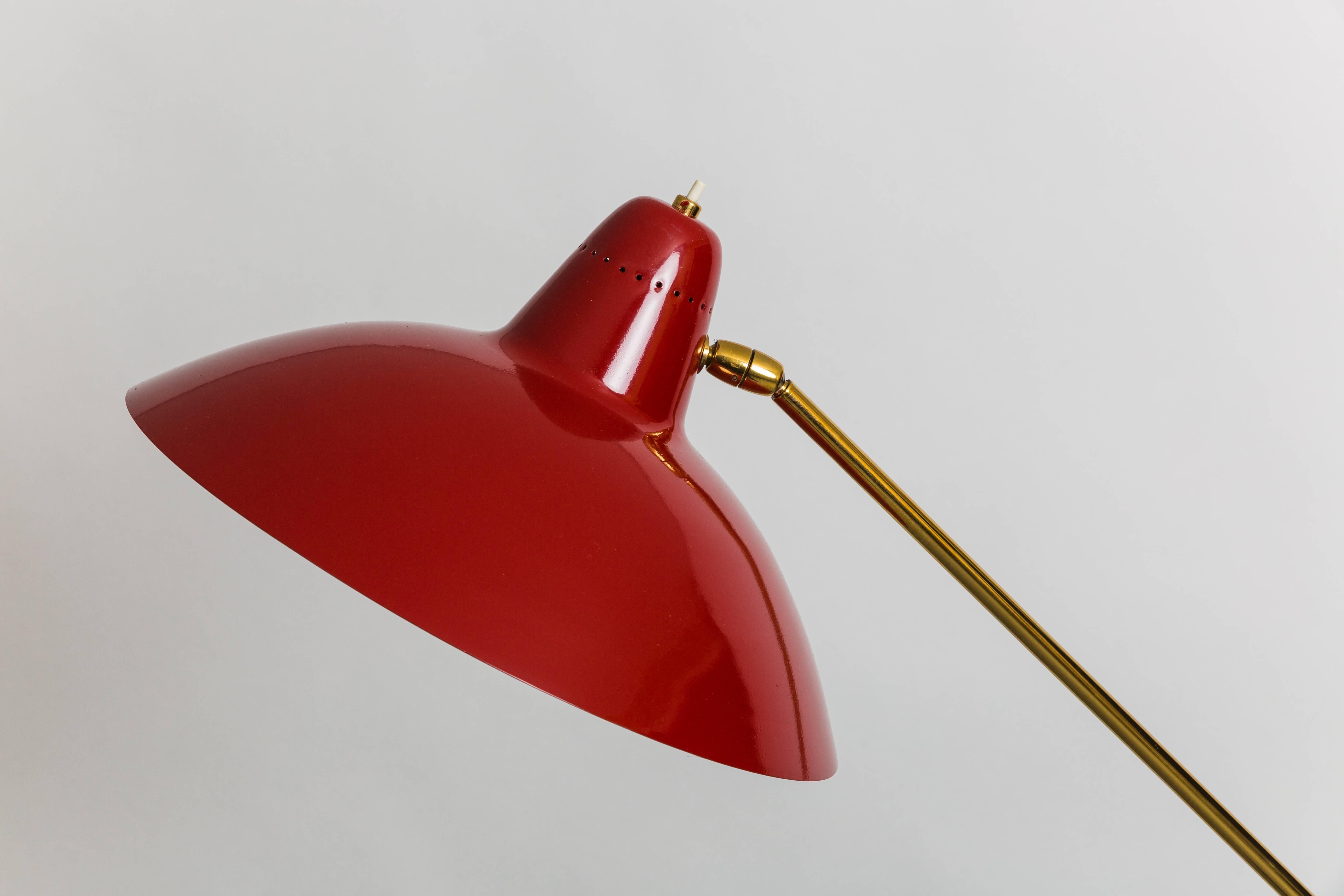Adjustable gilt lacquer brass stem and counterweight on black marble base with pivoting red lacquer metal lampshade, Italy, 1950s. 
Fully restored and rewired to U.S. standards.